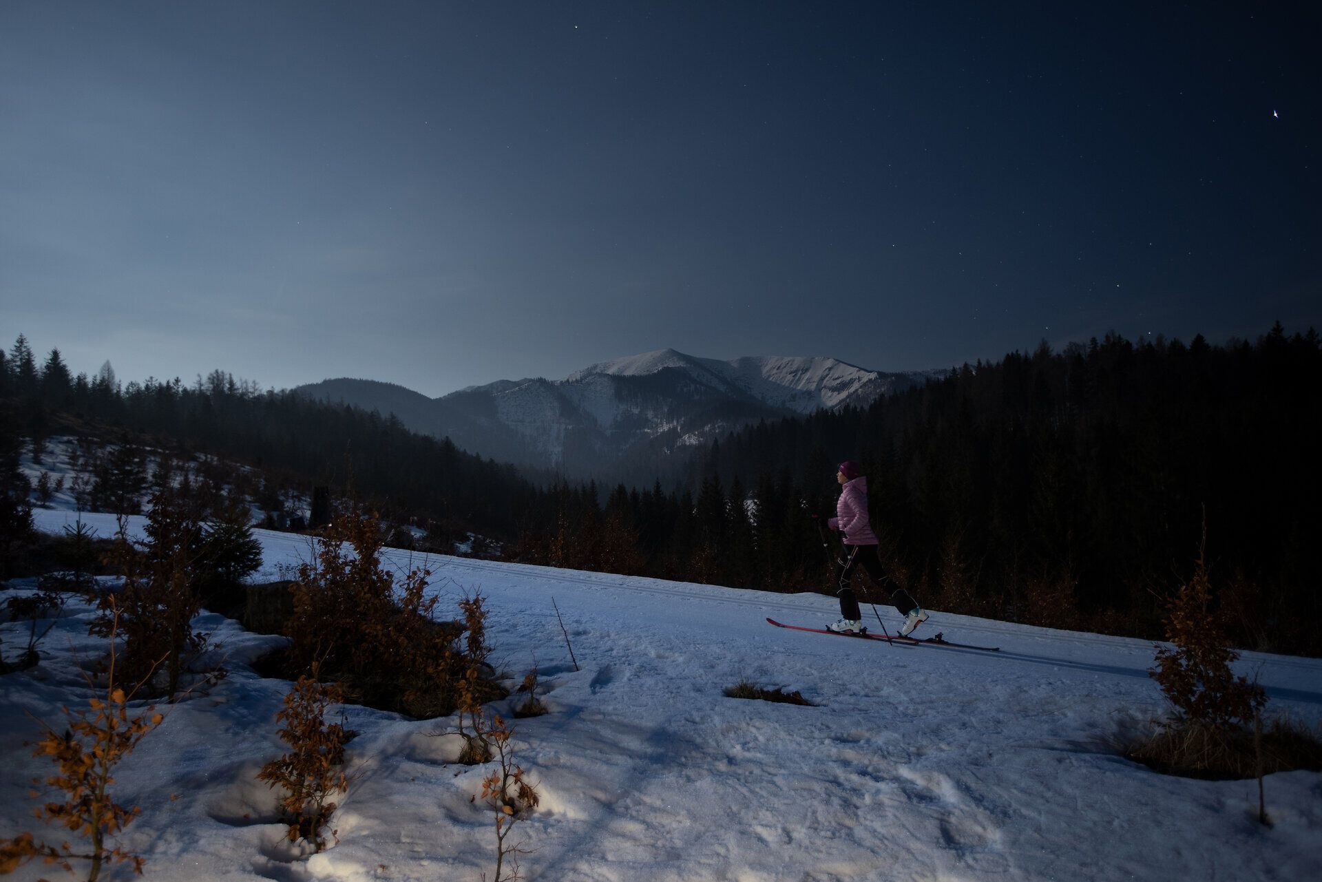 Unter dem klaren Sternenhimmel gleitet ein Skifahrer über die schneebedeckte Piste, umgeben von der majestätischen Berglandschaft. Die ruhige Nacht und die frische, kalte Luft schaffen eine magische Atmosphäre, die zum Träumen einlädt. Hier im Mariazellerland wird der Winter zum unvergesslichen Erlebnis.