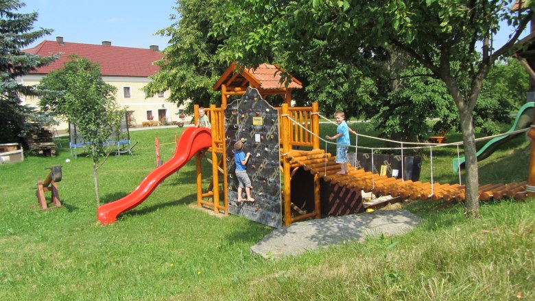 Steinursch, © Fam. Schagerl Spielplatz mit Klettergerüst, Rutsche und zwei Kindern beim Spielen.