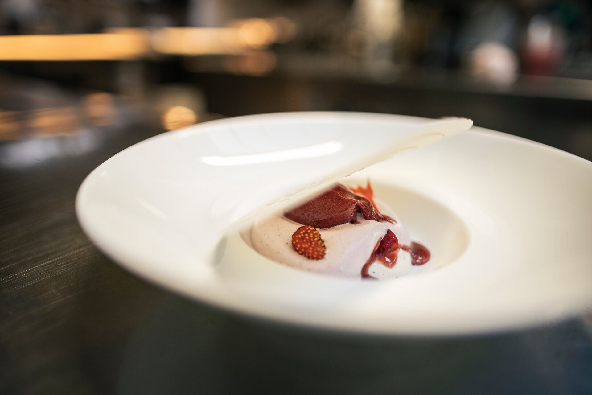 Gerichte sind kunstvoll auf weißen Tellern angerichtet.