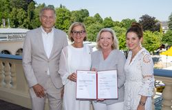 4 Personen mit der Urkunde auf der Terrasse des Congress Center Baden