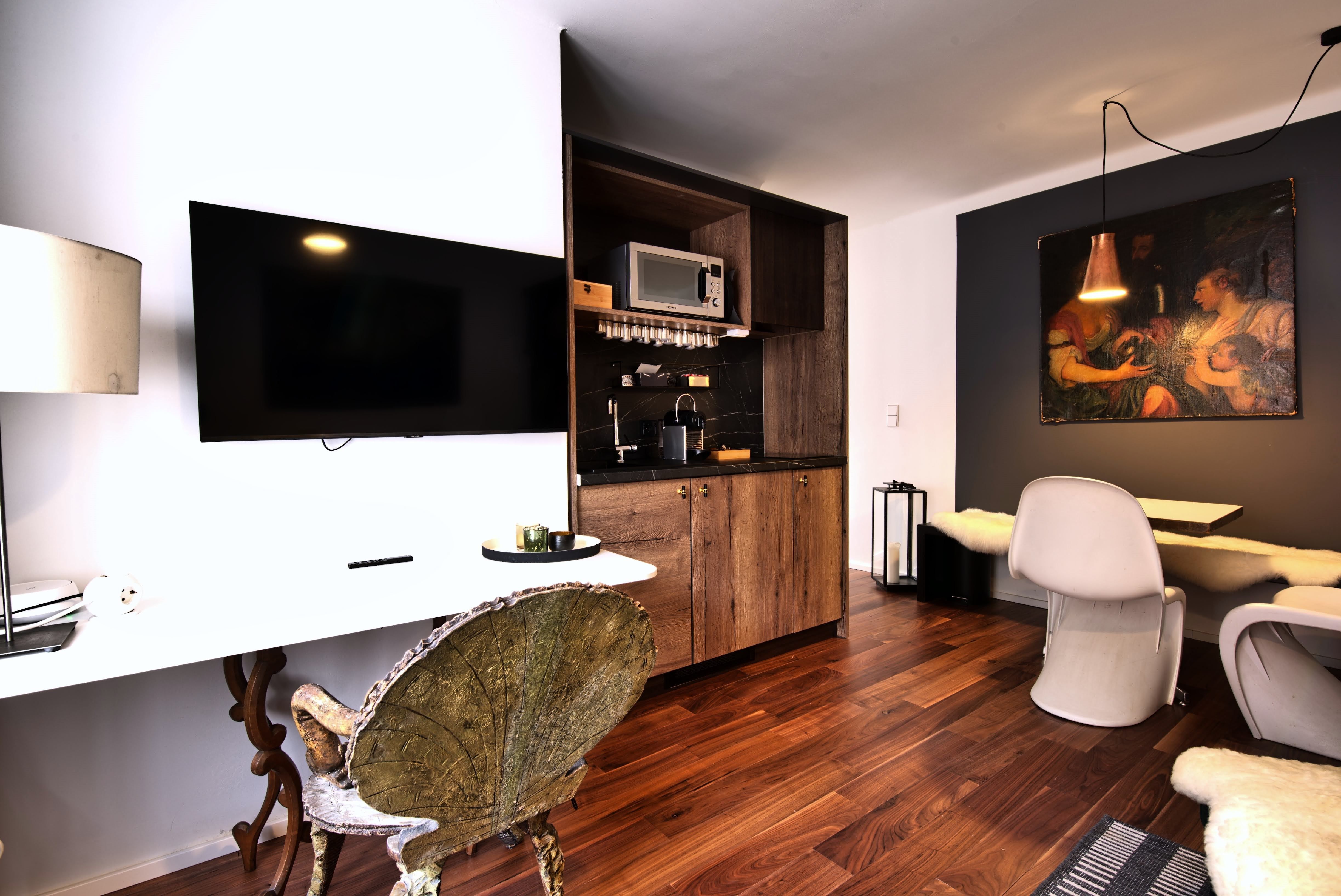 Moderne Küche mit Holzelementen, Flachbildfernseher und Essbereich.