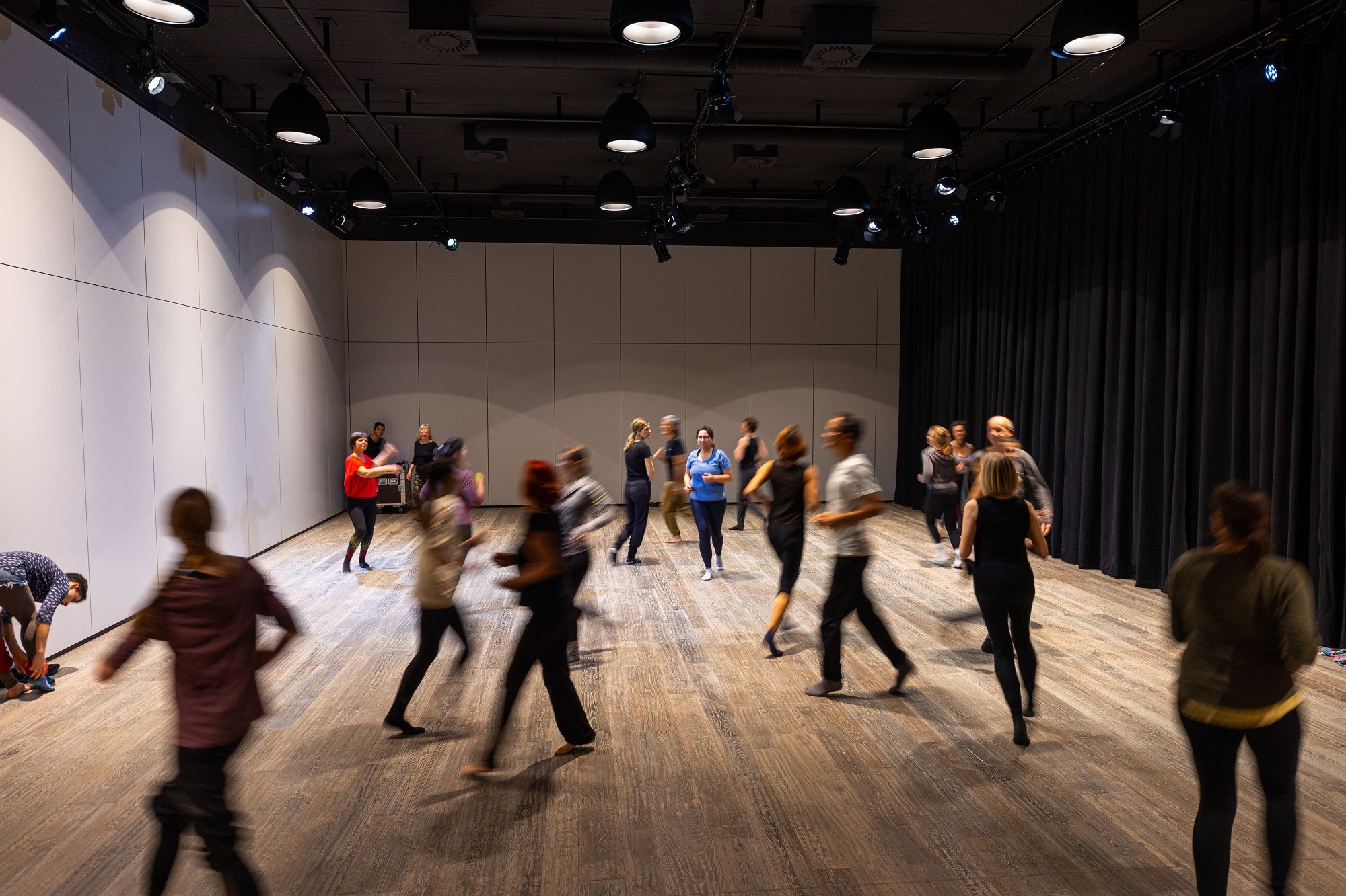 Menschen tanzen beim Theaterworkshop durch einen Raum