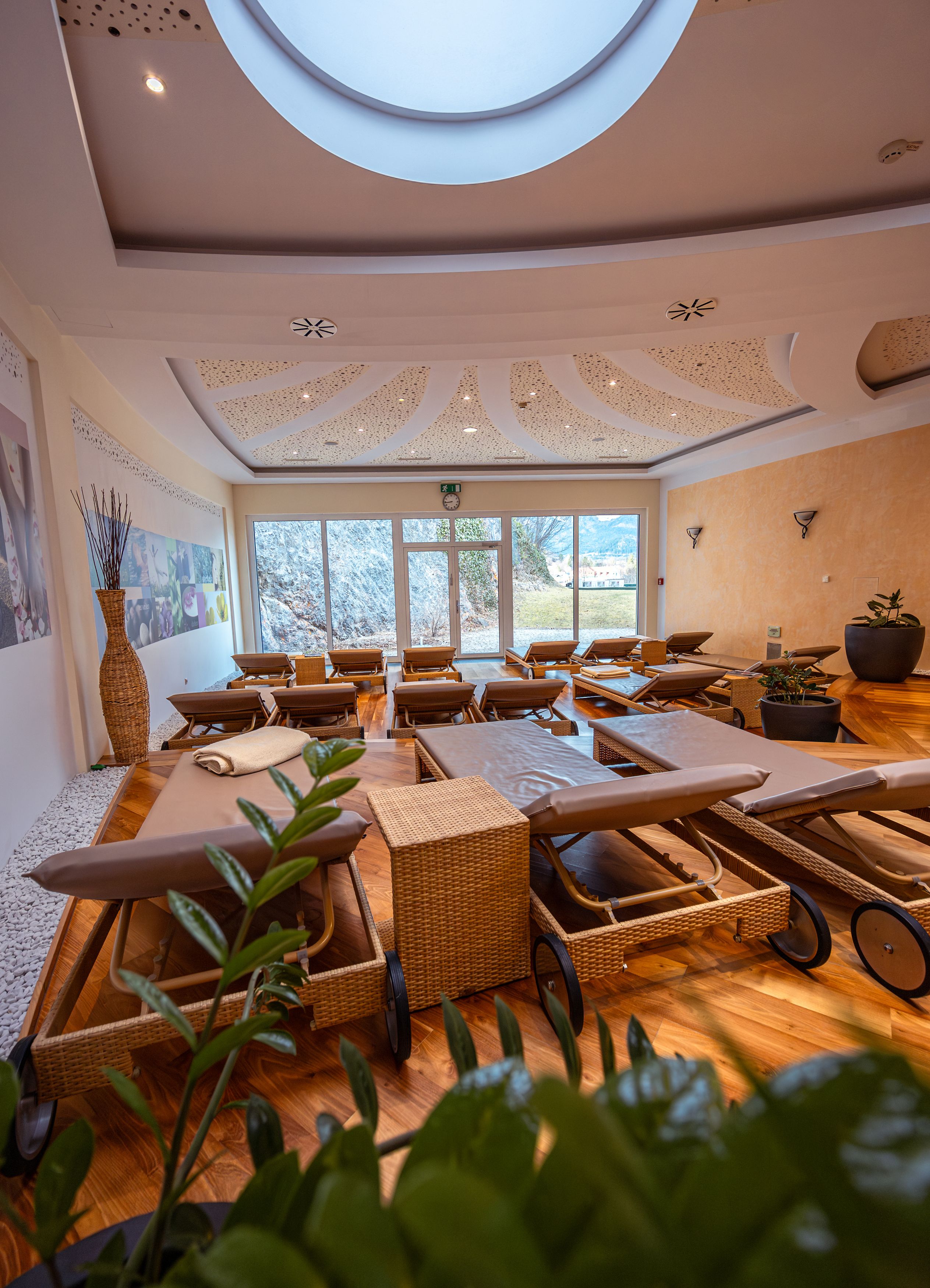Innenraum eines Wellnessbereichs mit Liegen und Pflanzen.