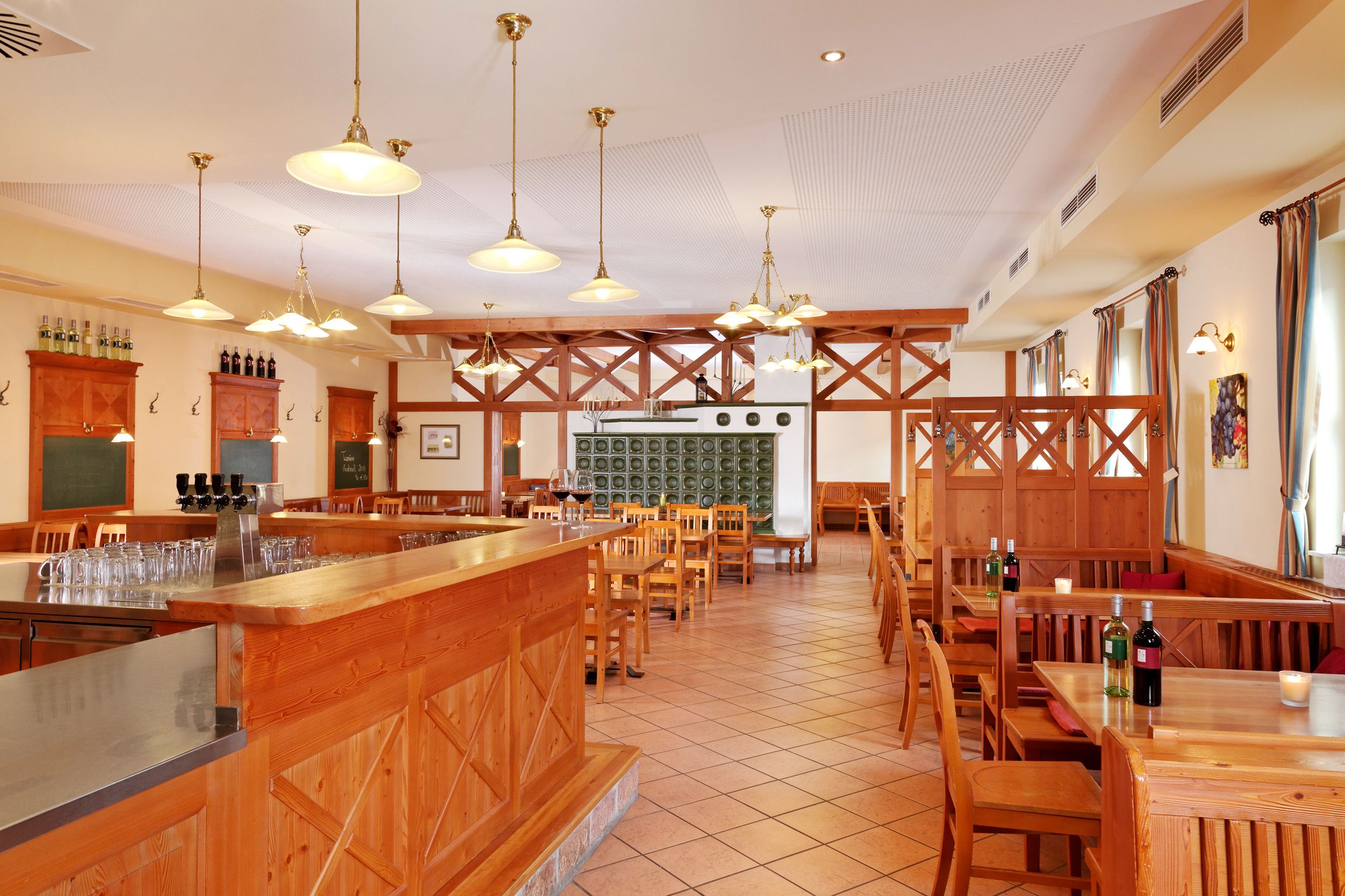 Innenansicht eines Heurigenlokals mit Holzmöbeln und Fliesenboden.