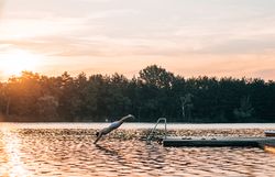 Ein erfrischender Sprung ins kühle Wasser des Viehofner Sees verspricht unvergessliche Sommertage. Die sanften Wellen spiegeln das goldene Licht der untergehenden Sonne wider und schaffen eine friedliche Atmosphäre, die zum Entspannen einlädt.