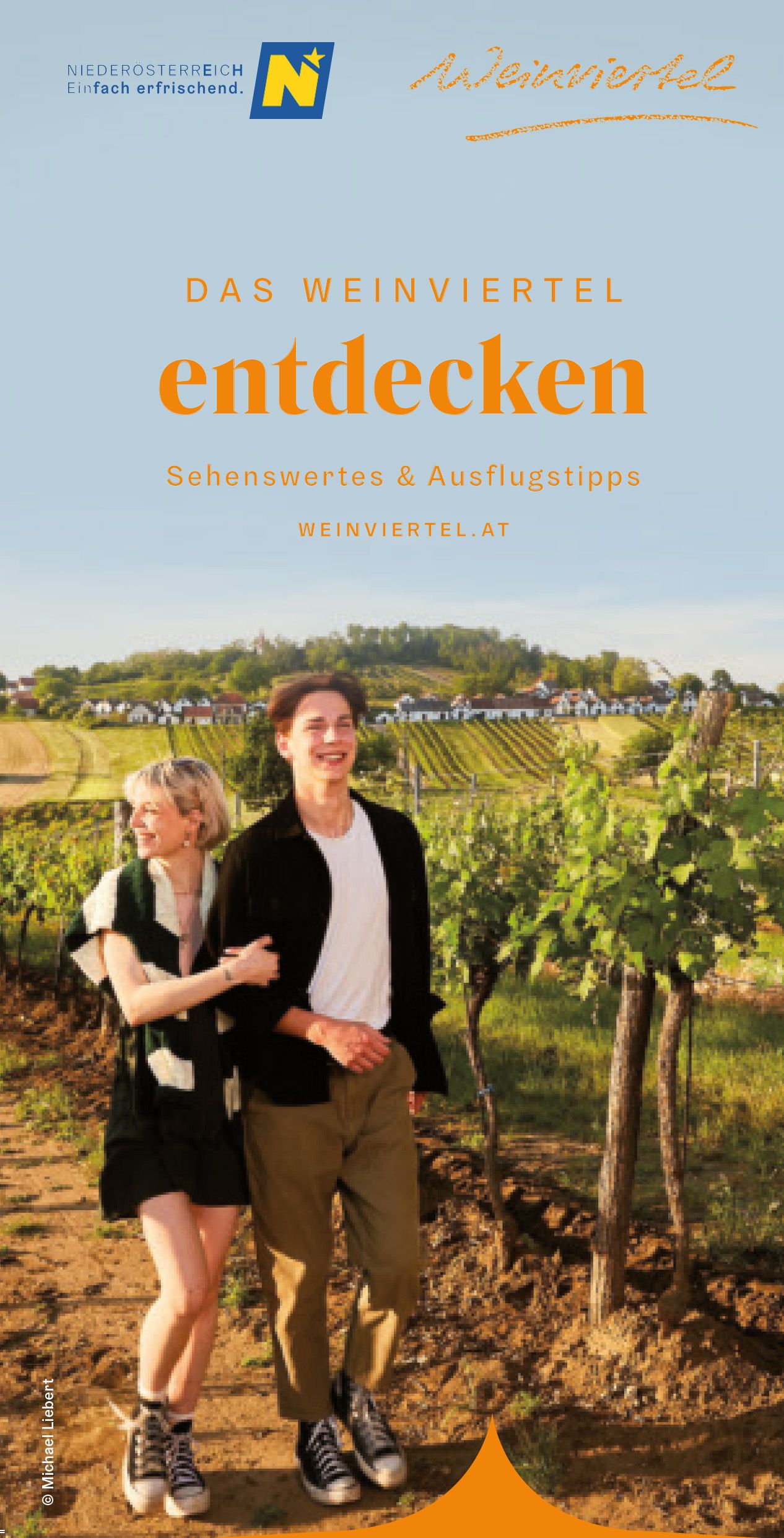 Cover: 2 Personen schlendern durch den Weingarten. Im Hintergrund die für das Weinviertel typischen Kellergassen (ehemaligen Produktionsstätten des Weins). 