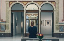 In einem beeindruckenden Museum, umgeben von kunstvoller Architektur, verweilt eine Besucherin in stiller Betrachtung. Die harmonische Verbindung von Kunst und Natur schafft eine inspirierende Atmosphäre, die zum Verweilen einlädt.