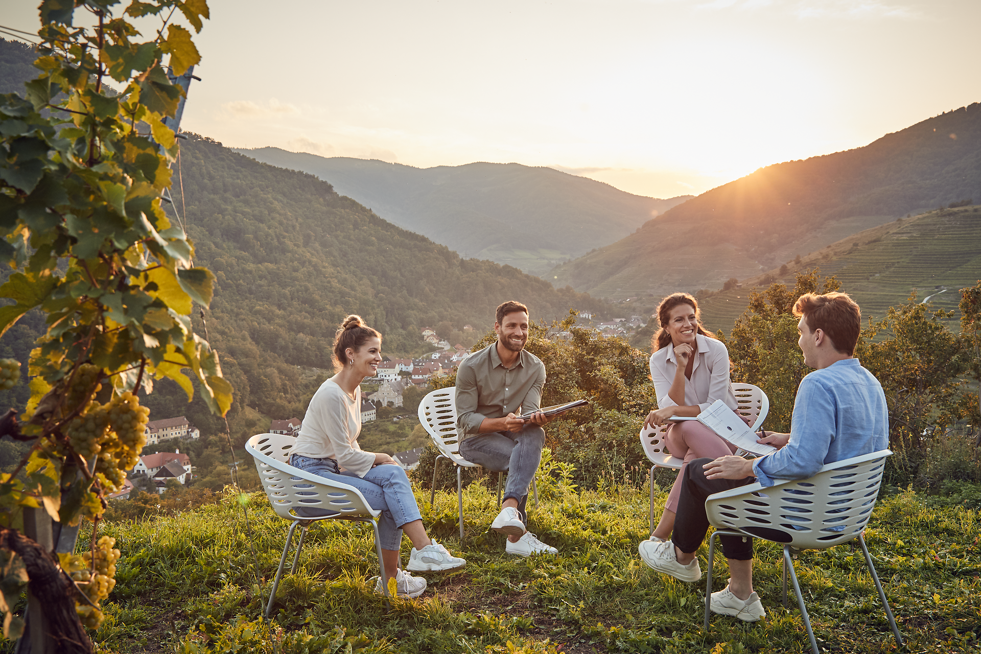 In der warmen Abendsonne versammeln sich Freunde inmitten einer atemberaubenden Landschaft. Umgeben von sanften Hügeln und Weinbergen genießen sie die entspannte Atmosphäre und die köstlichen Aromen der Natur. Diese idyllische Szenerie lädt dazu ein, die Schönheit des Sommers in den Bergen zu erleben.