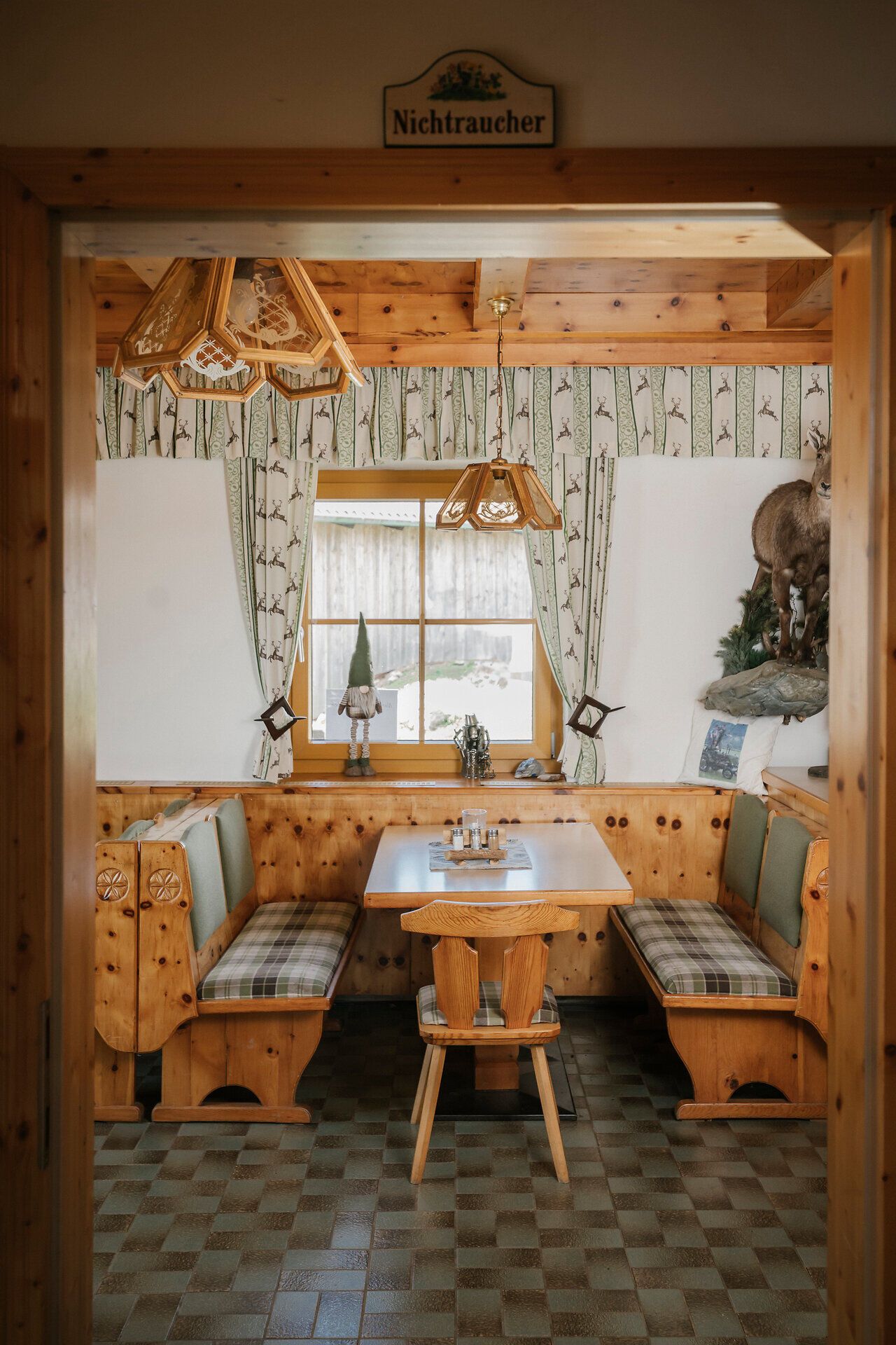 Rustikale Sitzecke mit Nichtraucherschild im Almreserlhaus am Schneeberg