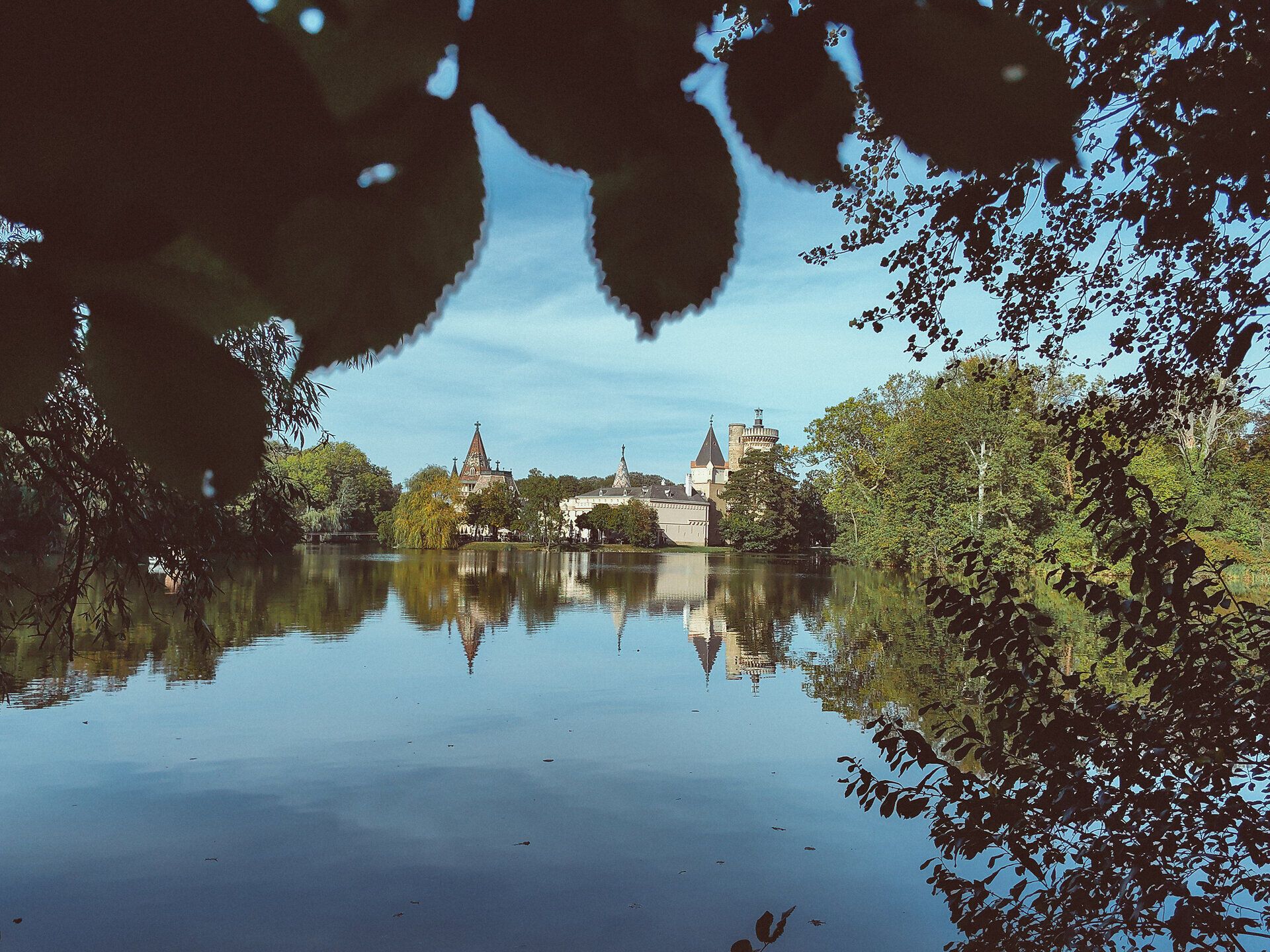 Die sanften Wellen des Wassers spiegeln die majestätischen Türme der Franzensburg wider, während die umgebenden Bäume in sattem Grün leuchten. Ein ruhiger Spaziergang entlang des Ufers lädt dazu ein, die friedliche Atmosphäre und die Schönheit der Natur zu genießen.