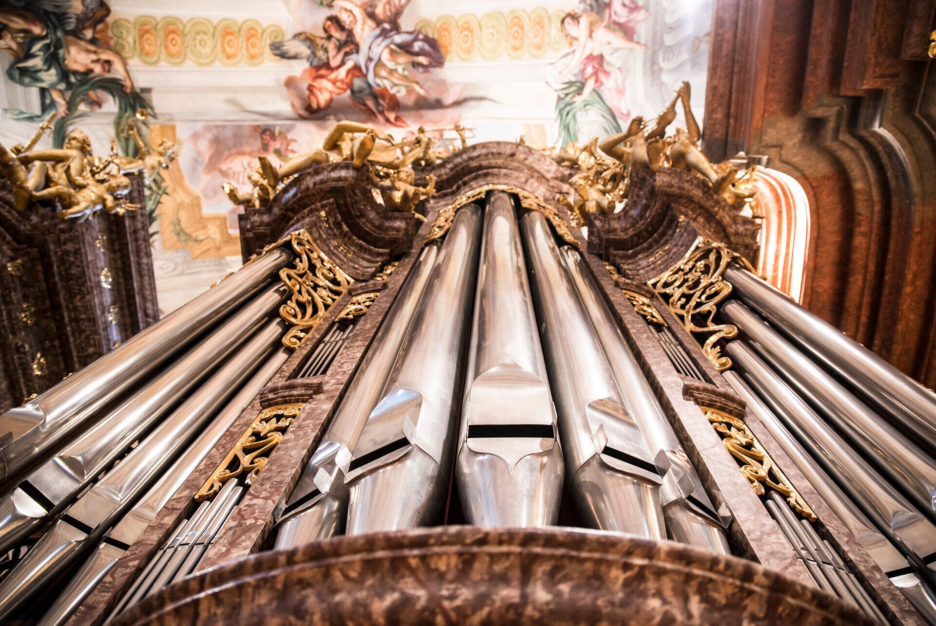 Die majestätischen Pfeifen des Orgelwerks erheben sich in den barocken Hallen und verleihen dem Raum eine ergreifende Akustik. Die kunstvollen Verzierungen und der Glanz des Metalls spiegeln die Pracht vergangener Zeiten wider und laden Besucher ein, in die musikalische Geschichte einzutauchen.