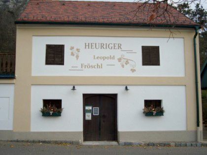 Fassade eines Heurigenlokals mit der Aufschrift 'Heuriger Leopold Fröschl'.