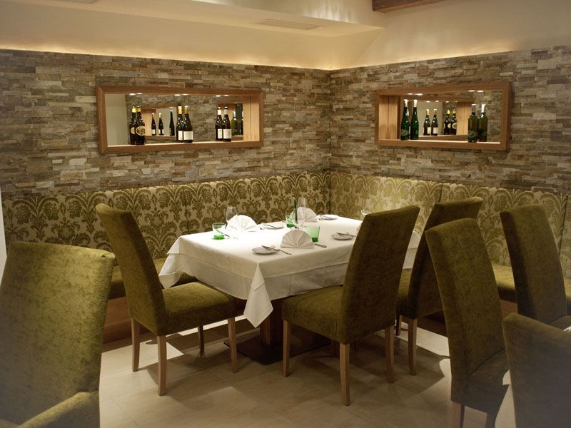 Elegantes Restaurant mit gedecktem Tisch und grünen Stühlen.