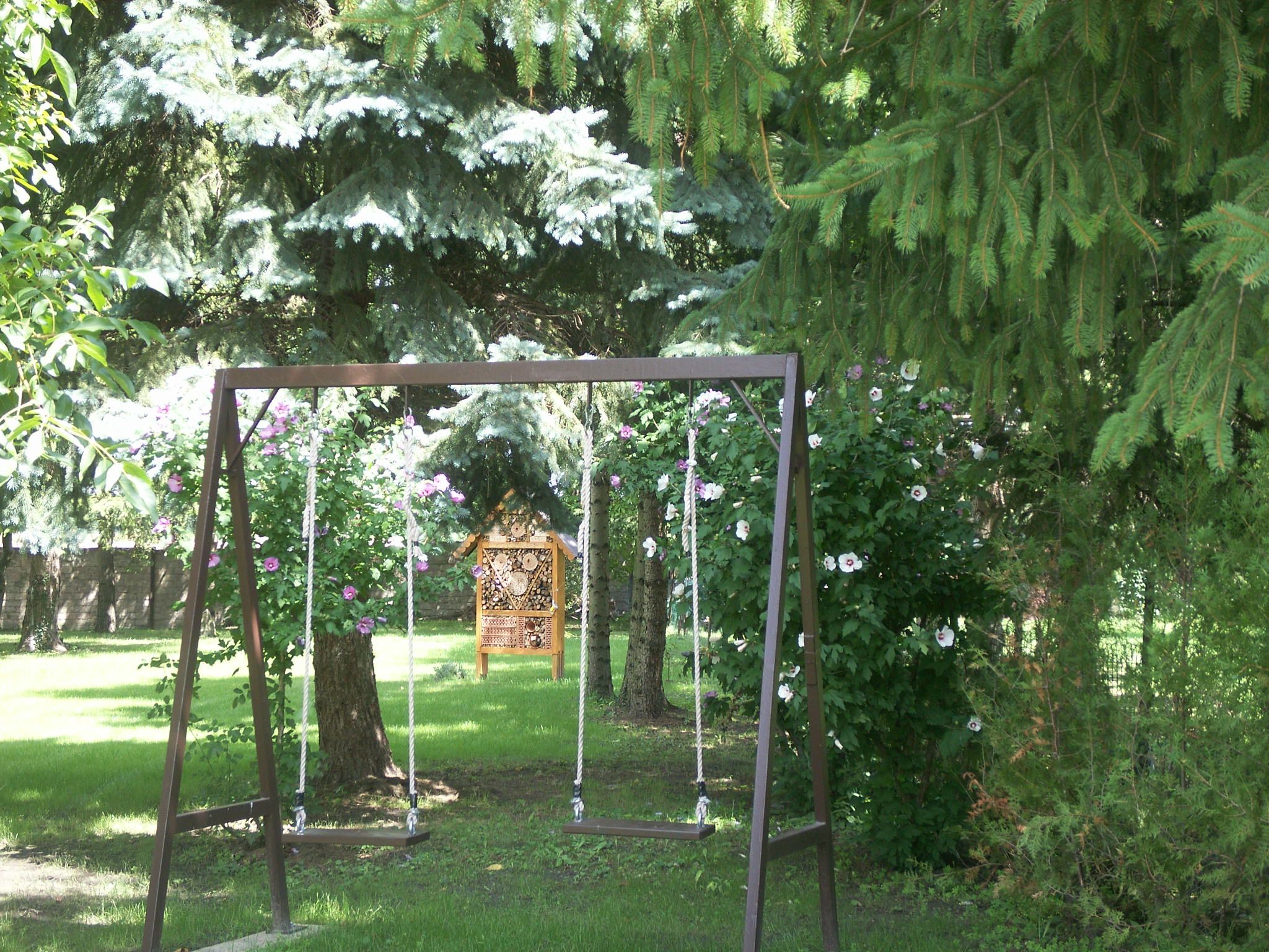 Garten mit Schaukel und Insektenhotel.
