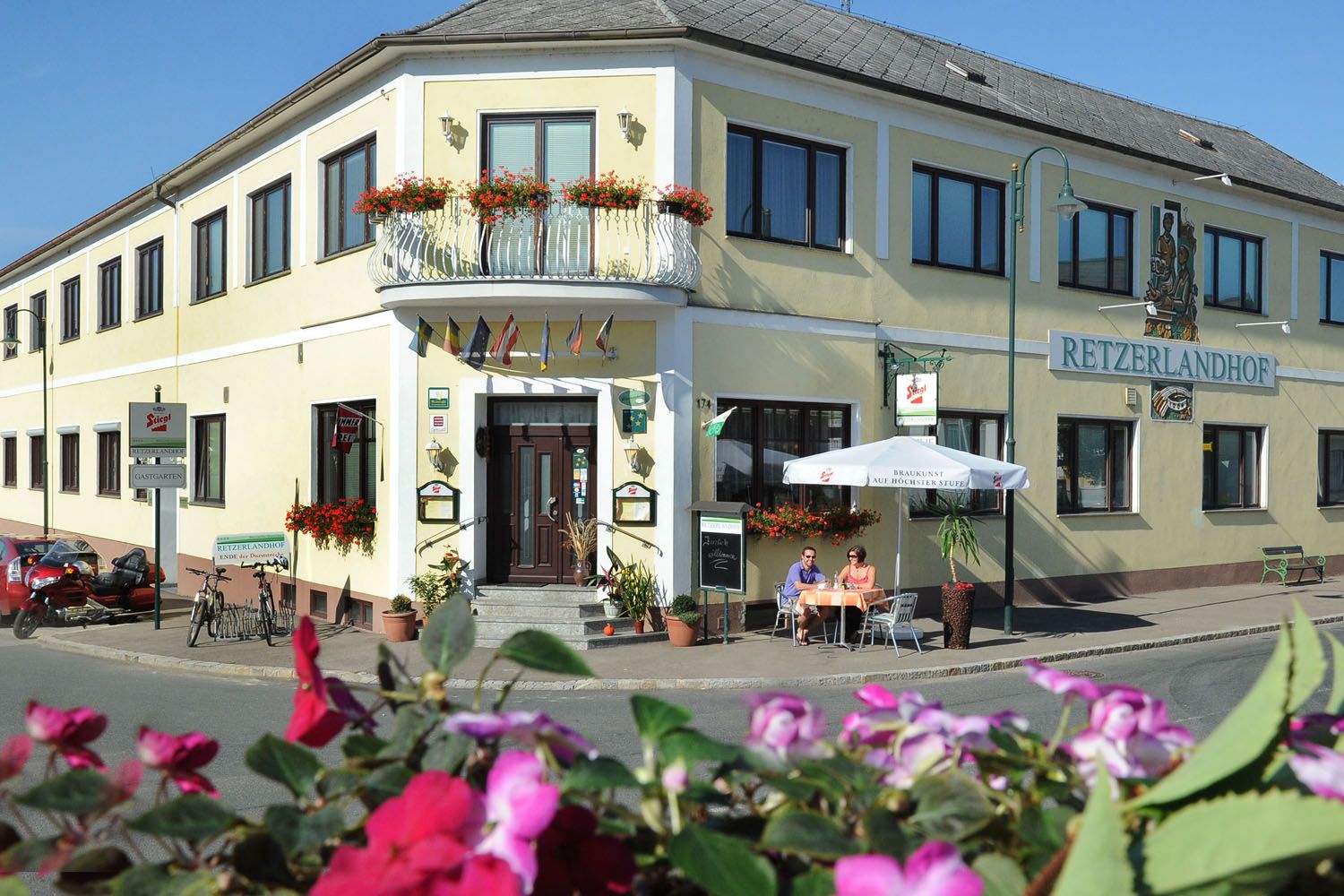 Außenansicht des Retzerlandhofs mit Terrasse und Blumen.