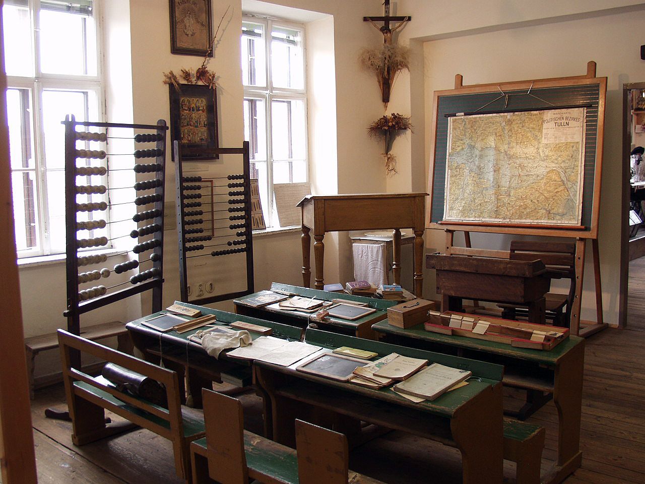 Historisches Klassenzimmer mit Abakus, Landkarte und alten Schulbänken.