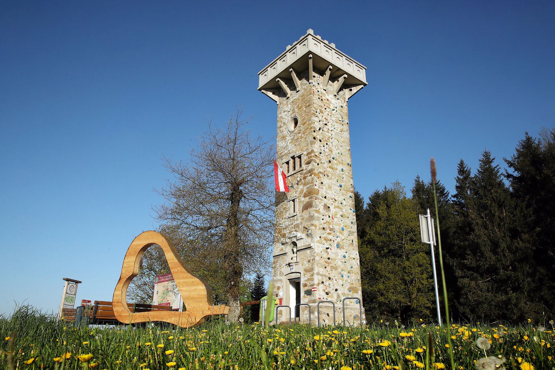 Aussichtsturm in ländlicher Hügellandschaft.