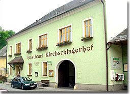 Ein traditionelles Gasthaus mit grüner Fassade und der Aufschrift 'Gasthaus Kirschlagerhof'.