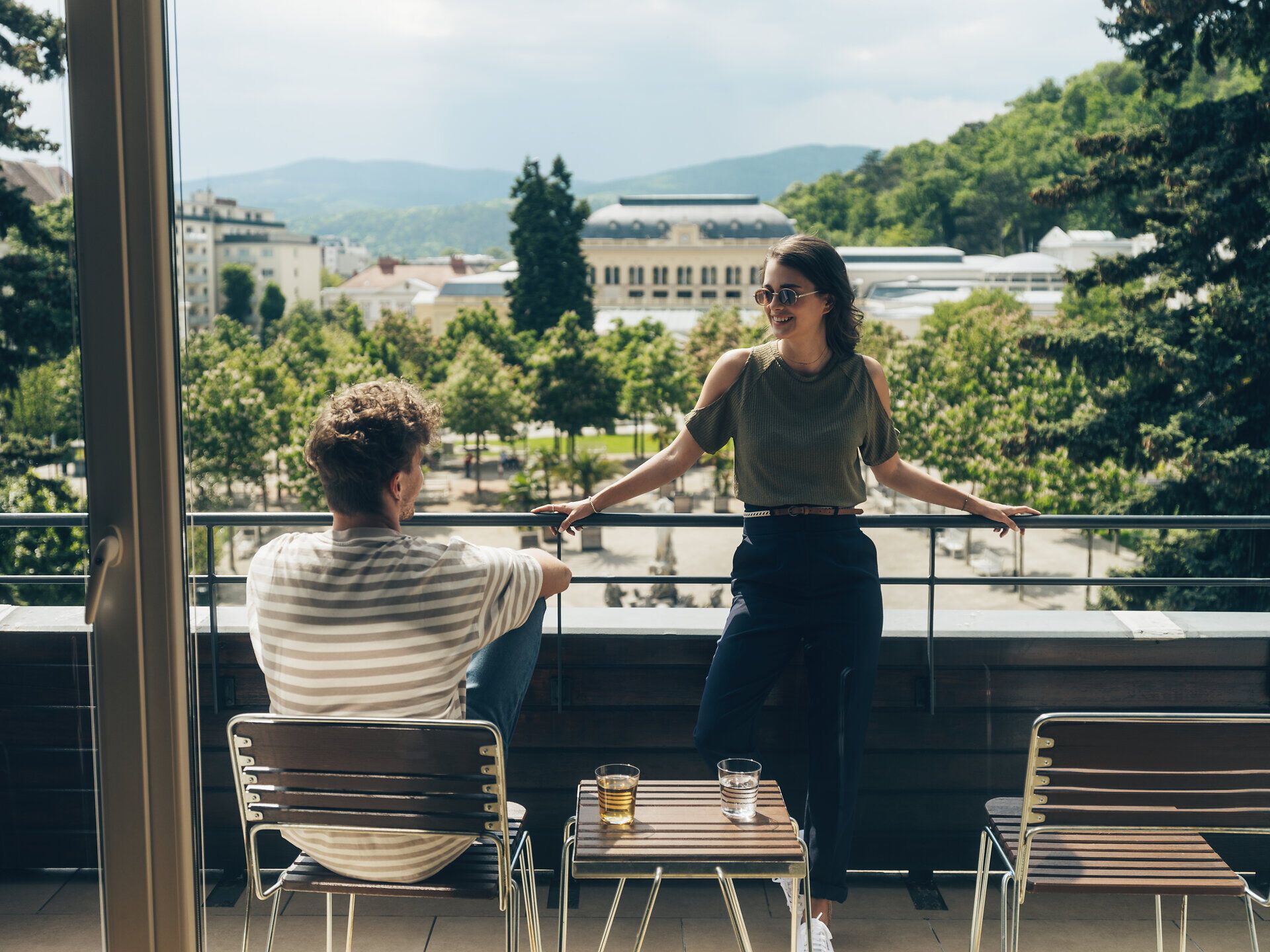 Ein stilvoll eingerichtetes Hotelzimmer mit einem großen roten Schuh als Bücherregal, antiken Stühlen, einem Tisch und einer Stehlampe.