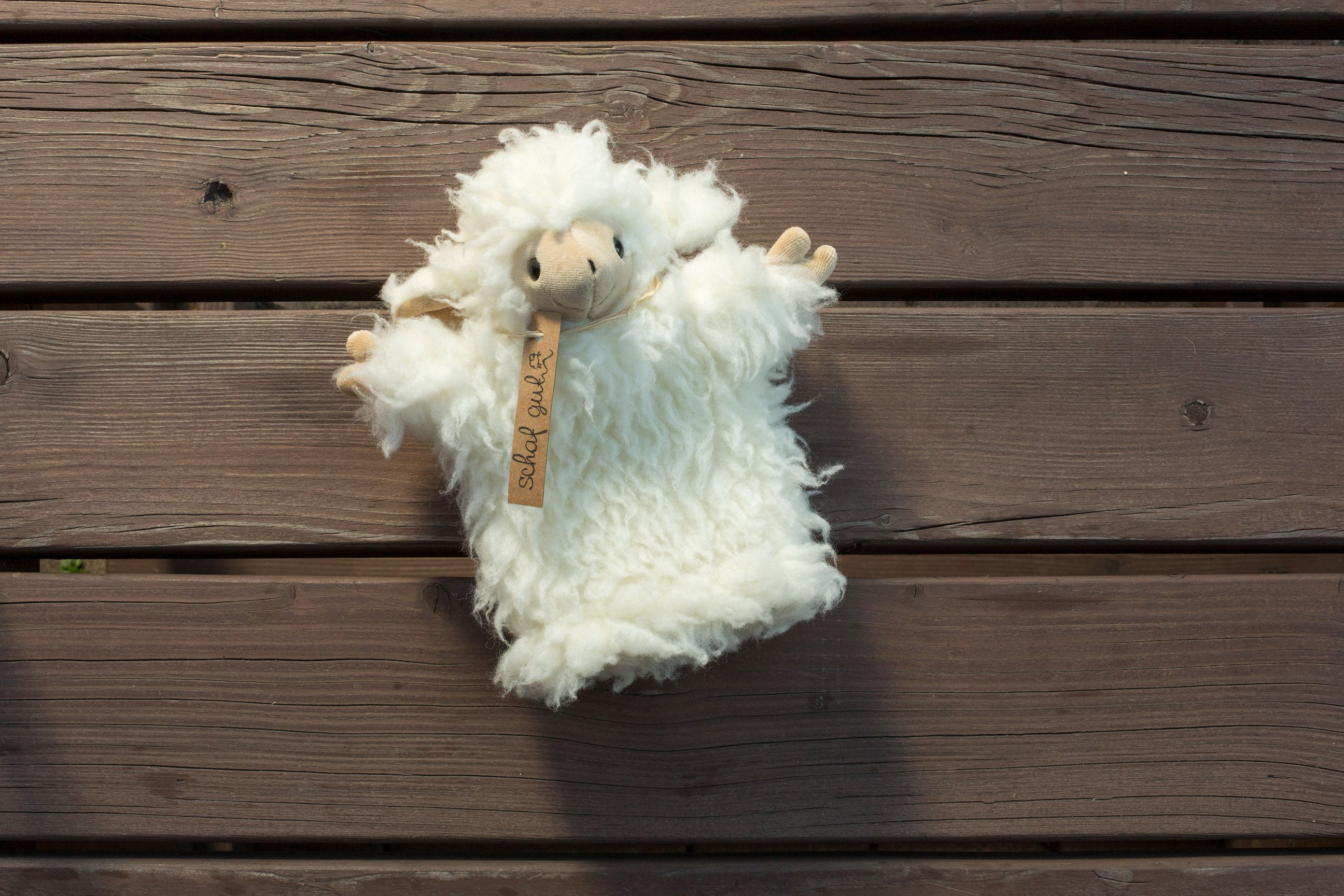 Handpuppe aus Schafwolle auf Holzhintergrund.