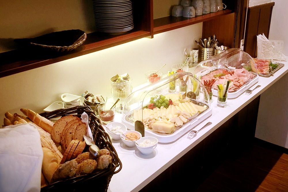 Frühstücksbuffet mit Brot, Aufschnitt und Käse.