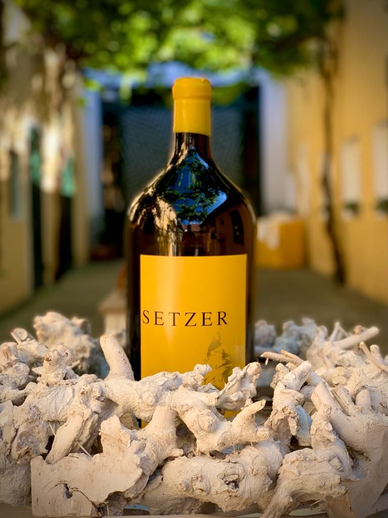 Magnumflasche Setzer-Wein in dekorativer Umgebung mit Holzstücken.