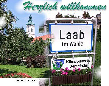 Willkommensschild von Laab im Walde mit Kirche im Hintergrund.