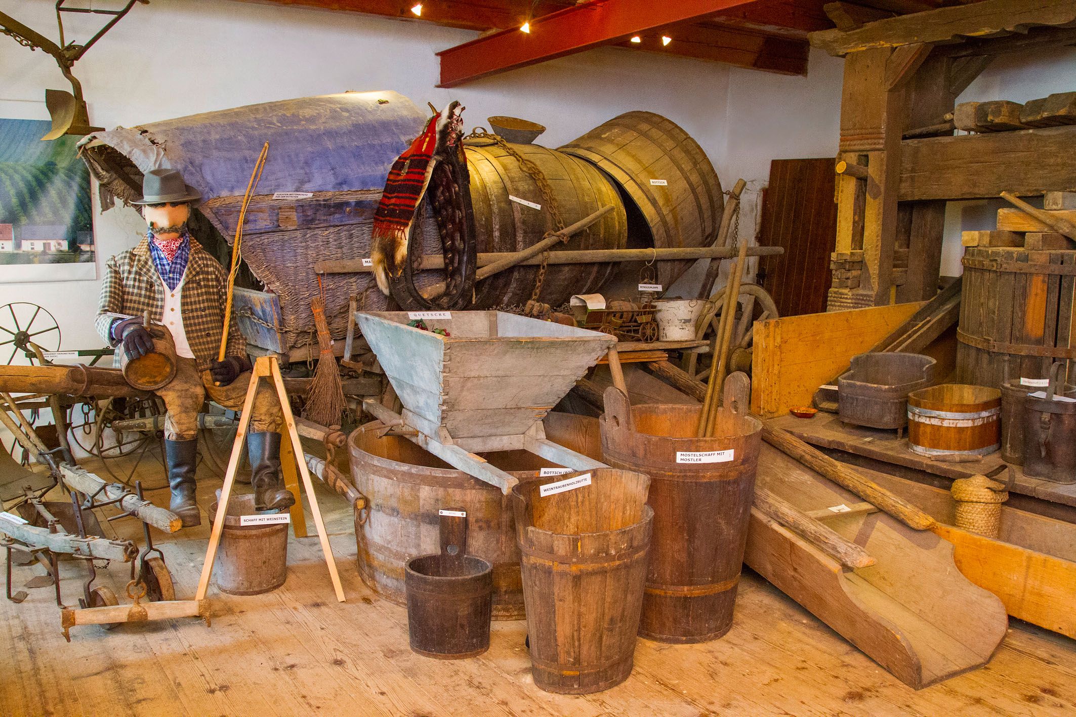 Ausstellung mit alten landwirtschaftlichen Geräten und Holzfässern.