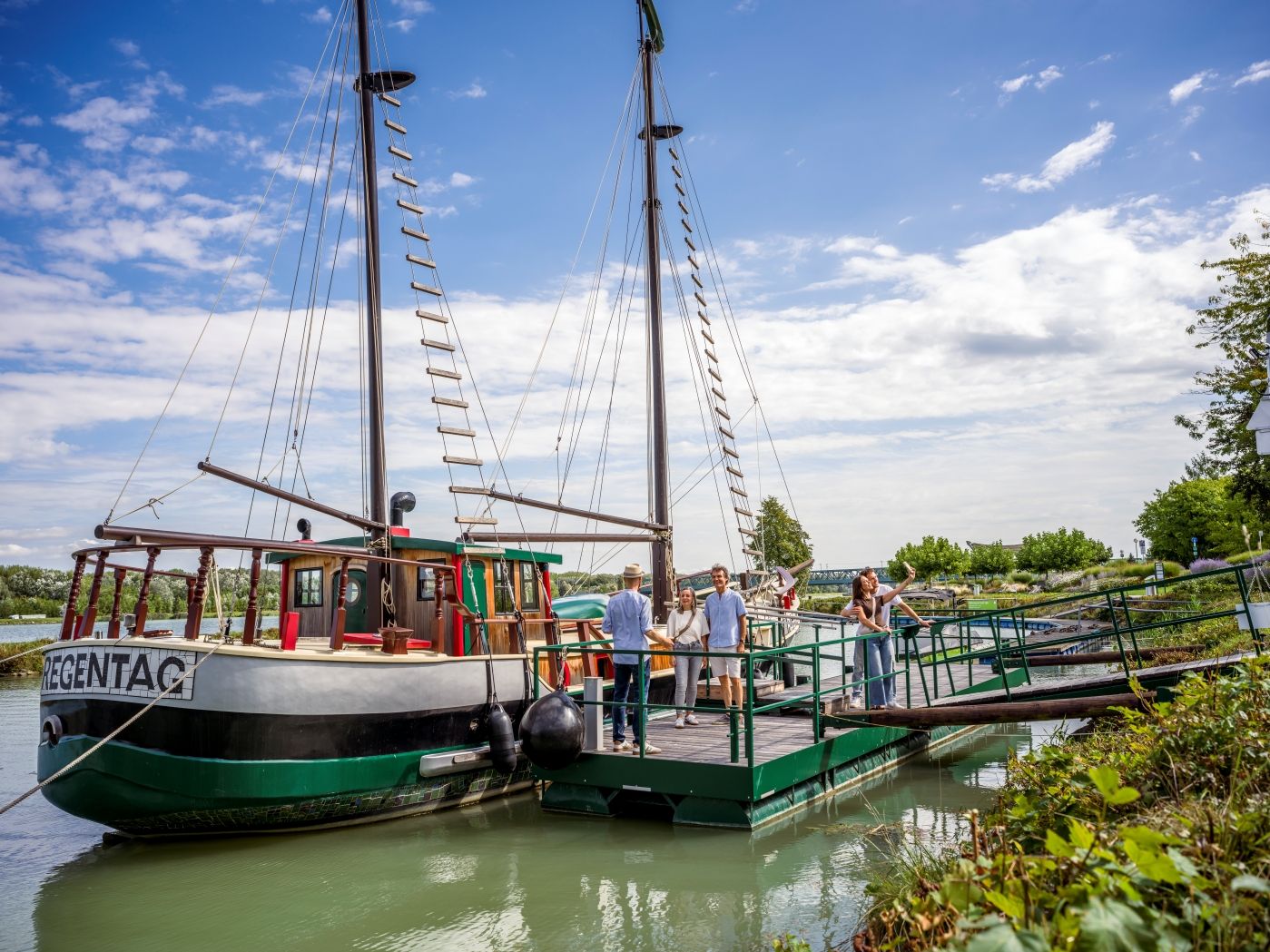 Menschen am Bootssteg vor dem historischen Hundertwasser-Schiff "Regentag" 