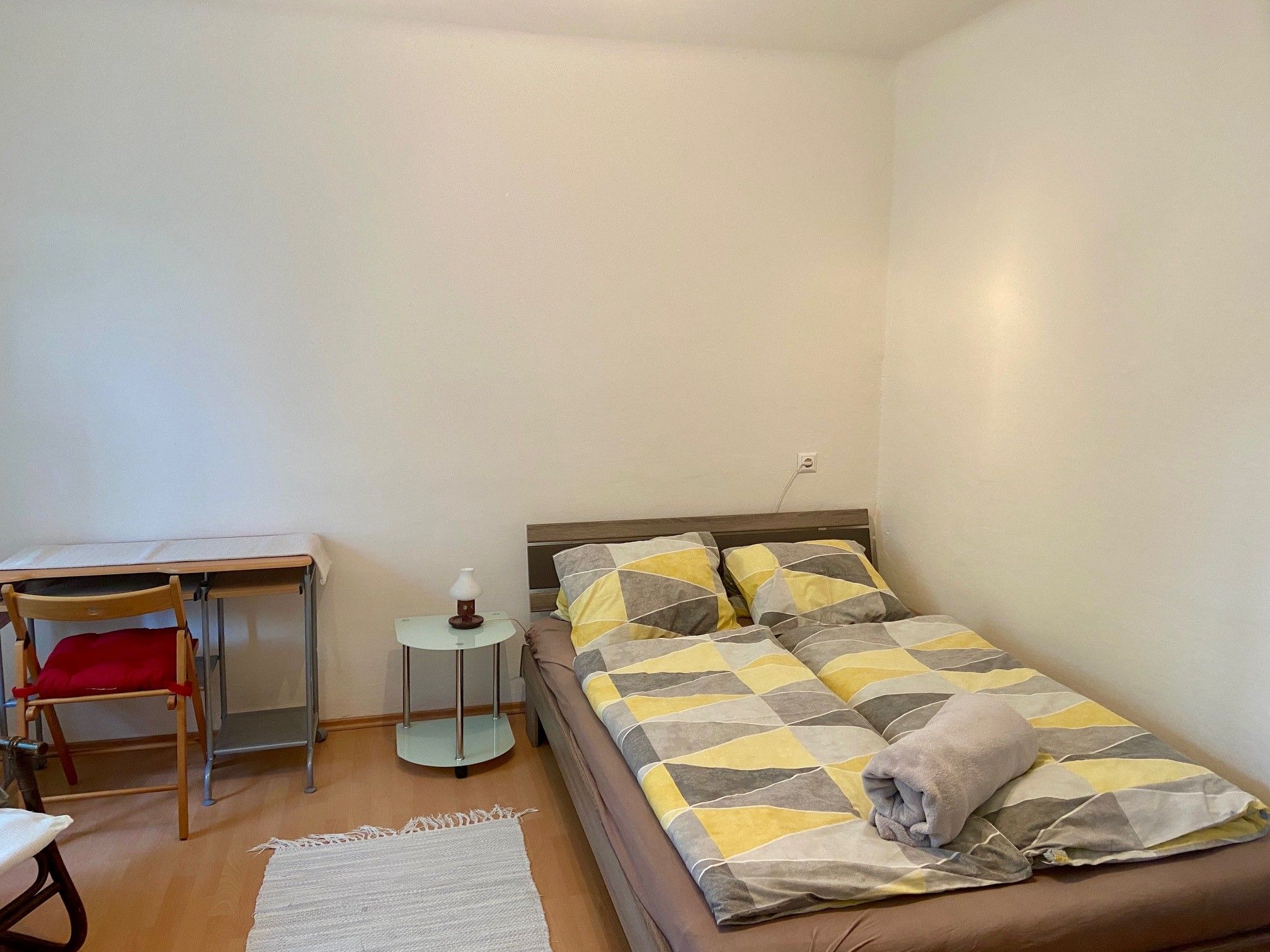 Schlafzimmer mit Doppelbett, Schreibtisch und Stuhl.