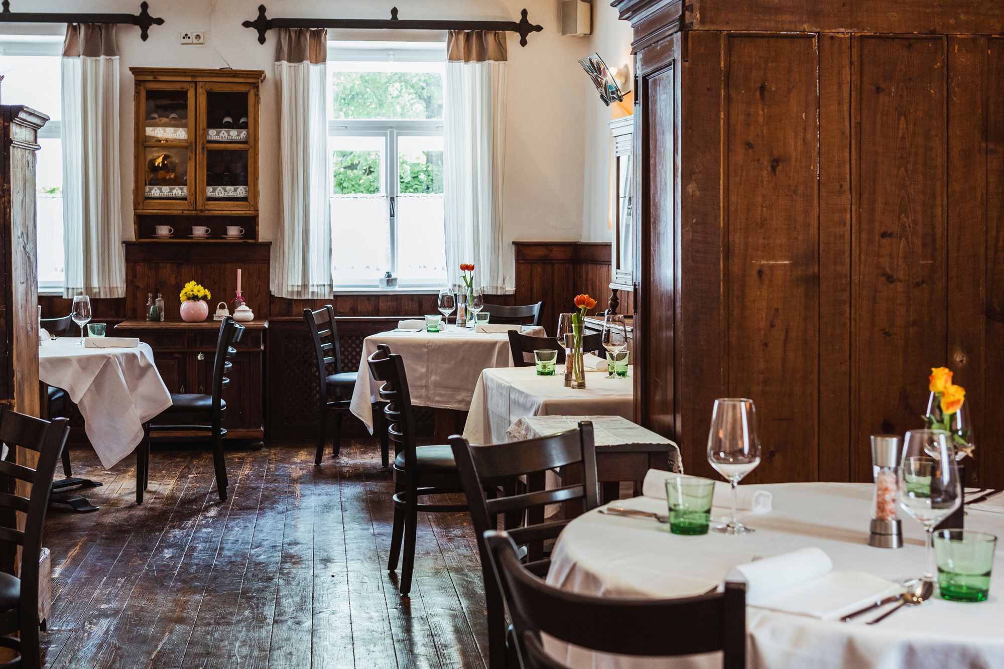 Gemütliches Wirtshaus mit Holzmöbeln und gedeckten Tischen.