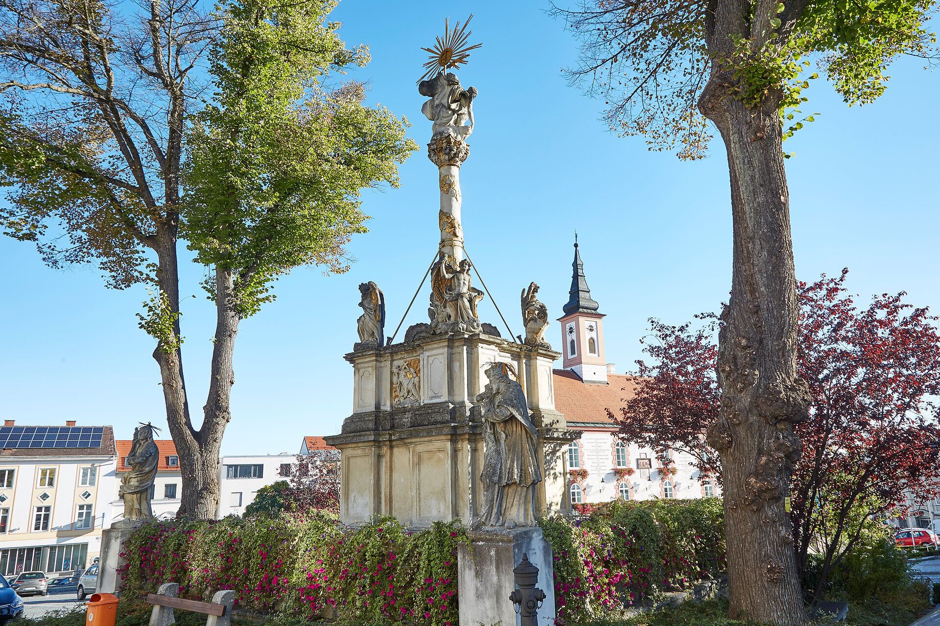In der malerischen Stadtmauerstadt Waidhofen an der Thaya erhebt sich ein beeindruckendes Denkmal, umgeben von üppigem Grün und bunten Blumen. Die strahlende Sonne taucht die Szenerie in warmes Licht und lädt dazu ein, die historische Atmosphäre und die Schönheit der Umgebung zu genießen.