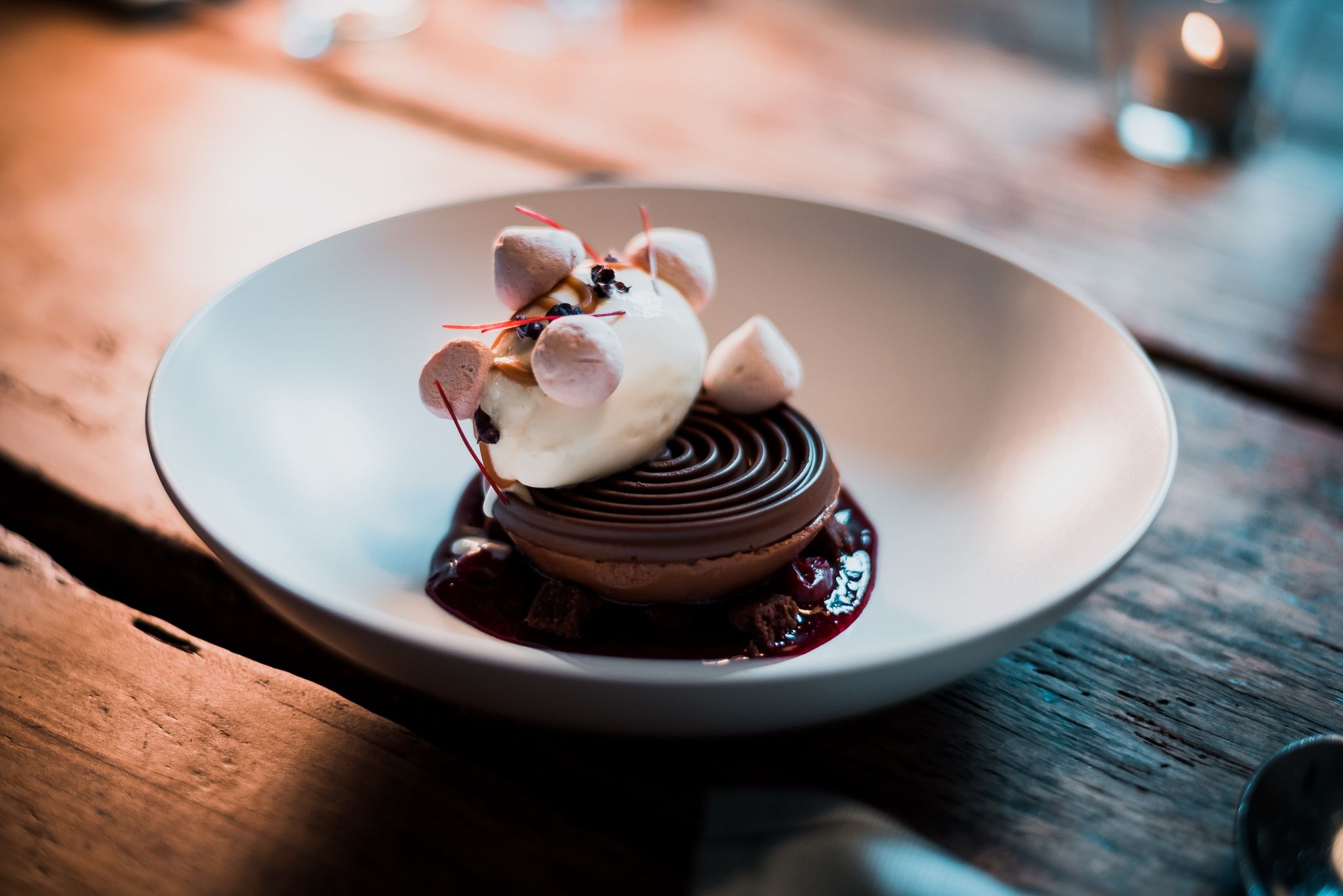 Ein Dessert mit Eis, Mousse und Crumble in einer Schale serviert.