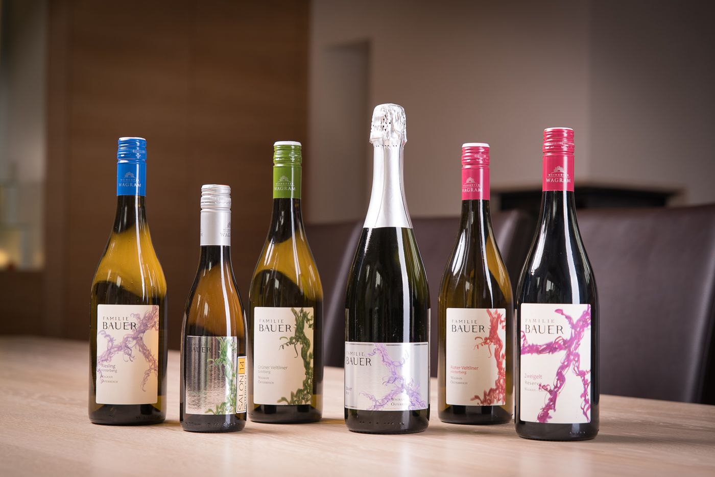 Sechs Weinflaschen der Familie Bauer auf einem Tisch.