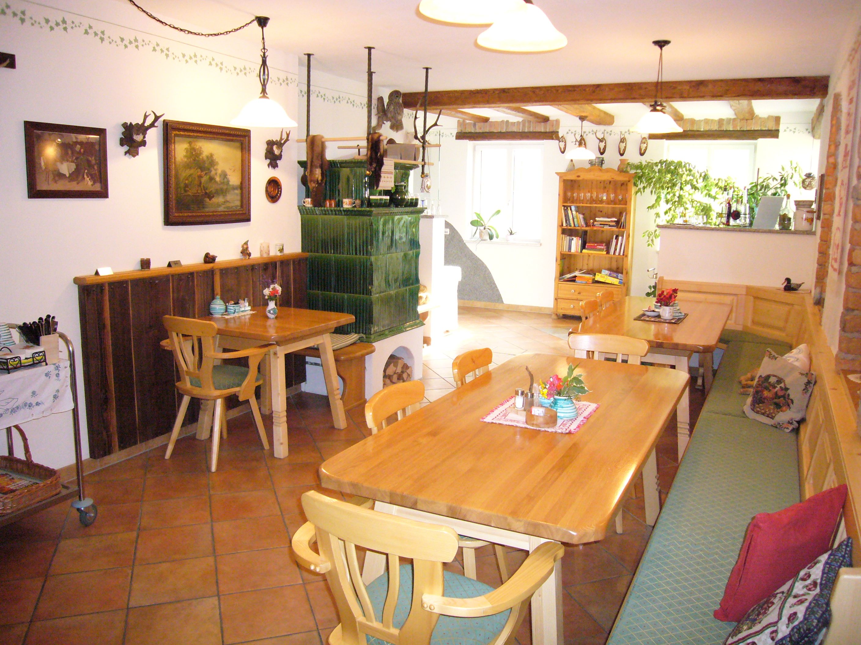 Gemütlicher Gastraum mit Holzmöbeln und Kachelofen.