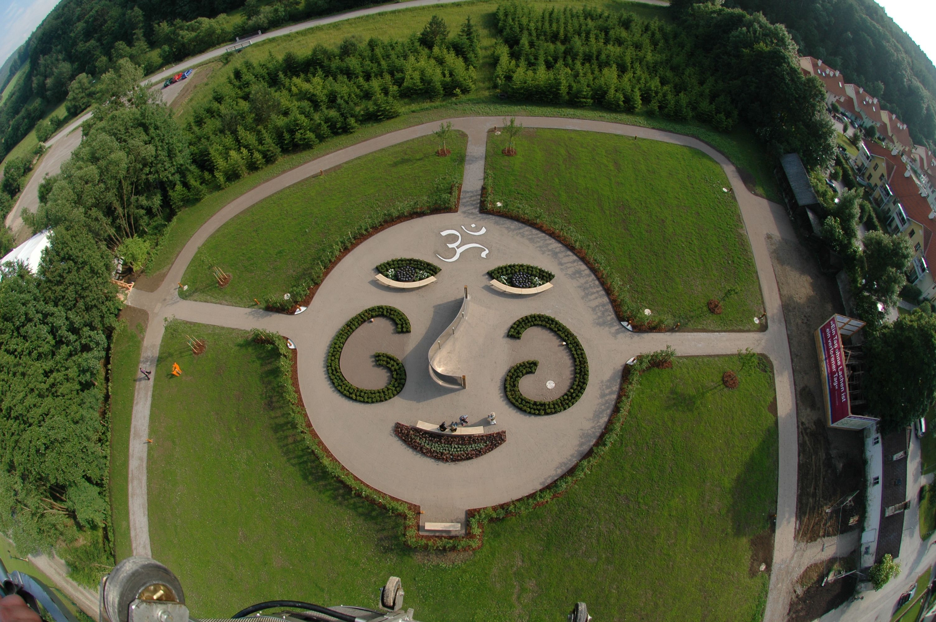 Luftaufnahme eines Gartens mit Gesichtsmuster aus Pflanzen und Wegen.