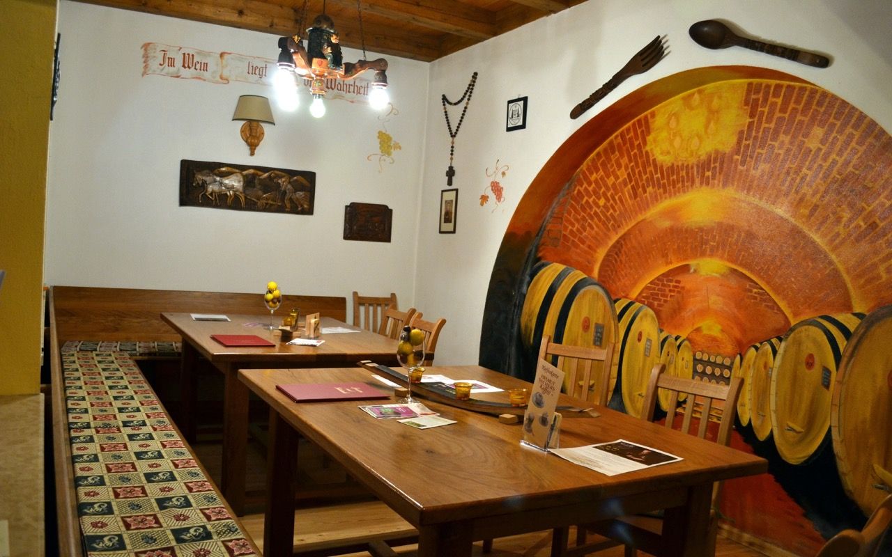 Gemütliche Stube der Lössiade mit Holztischen, warmem Licht und traditioneller Einrichtung.