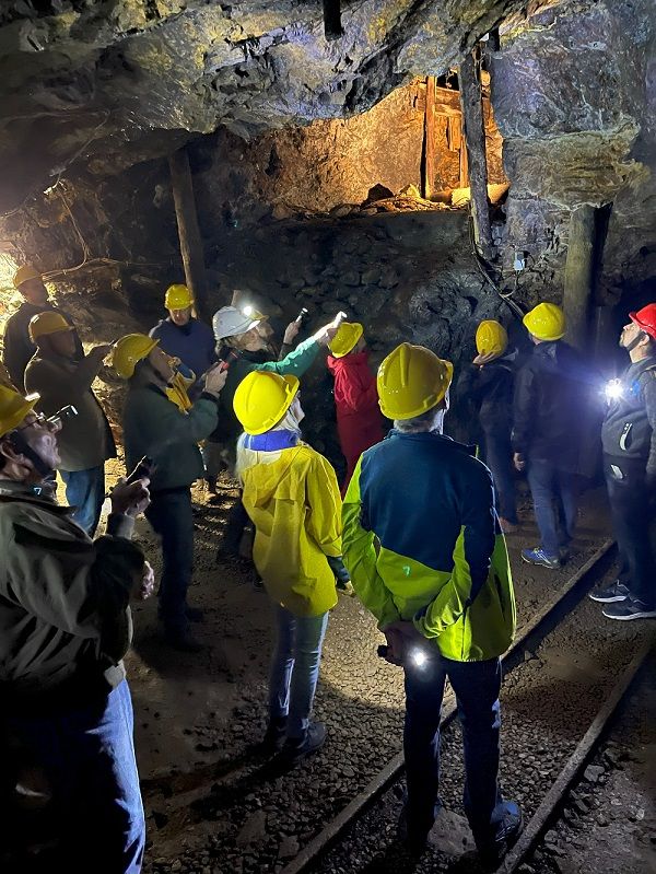 Gruppe von Menschen mit Helmen in einer beleuchteten Höhle.