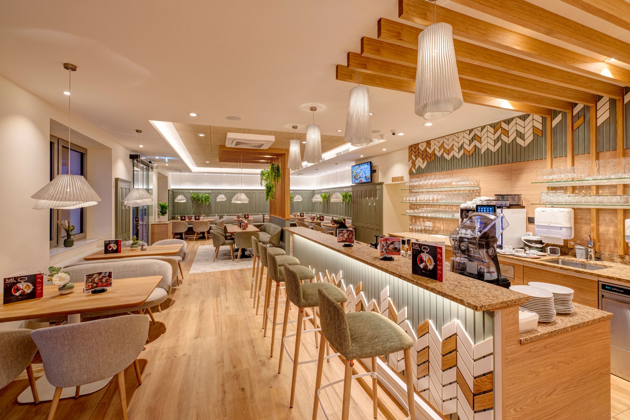 Moderner Cafébereich mit Holzmöbeln und Bar.