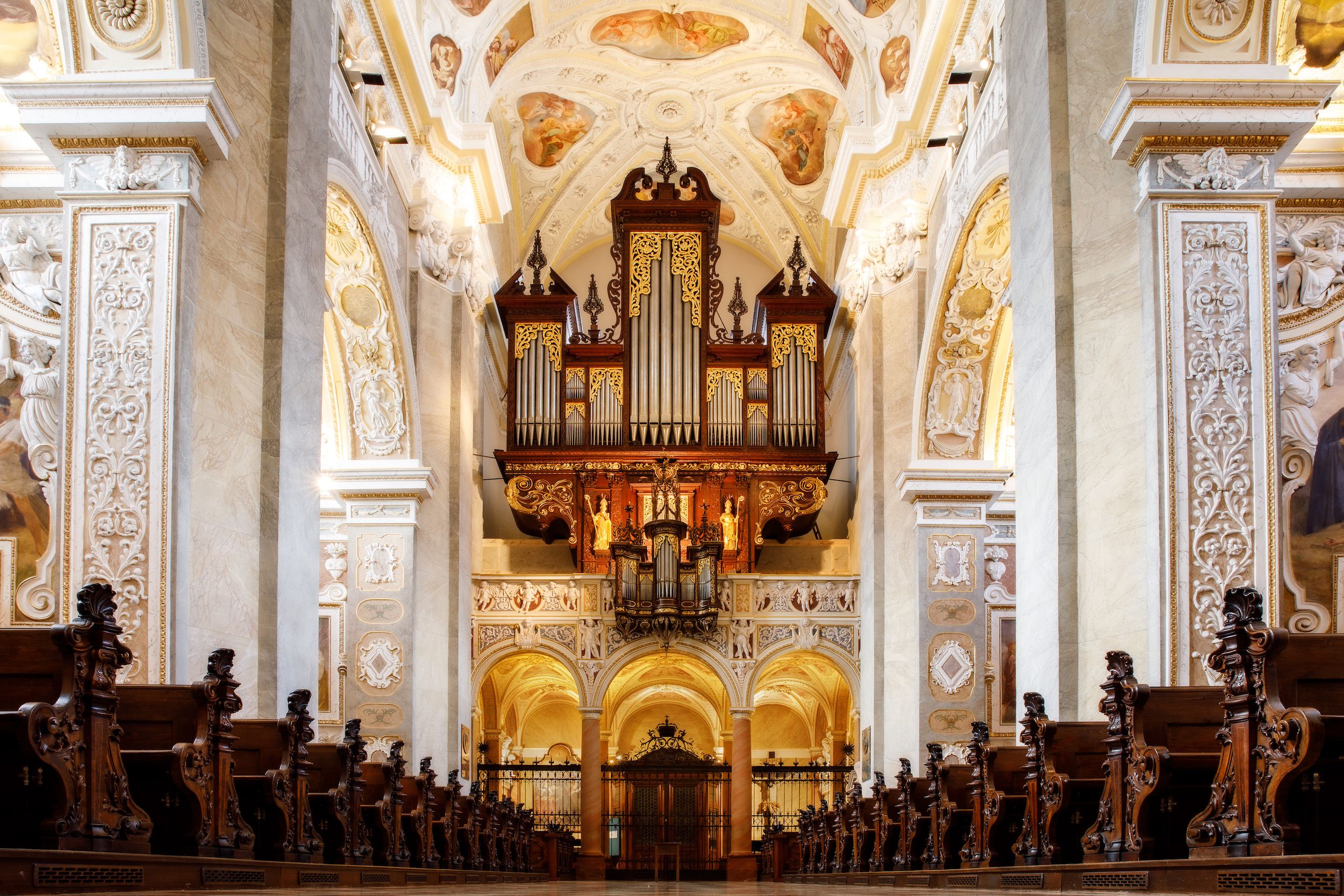 Prächtige Orgel in einer reich verzierten Kirche mit kunstvollen Holzschnitzereien und Fresken.