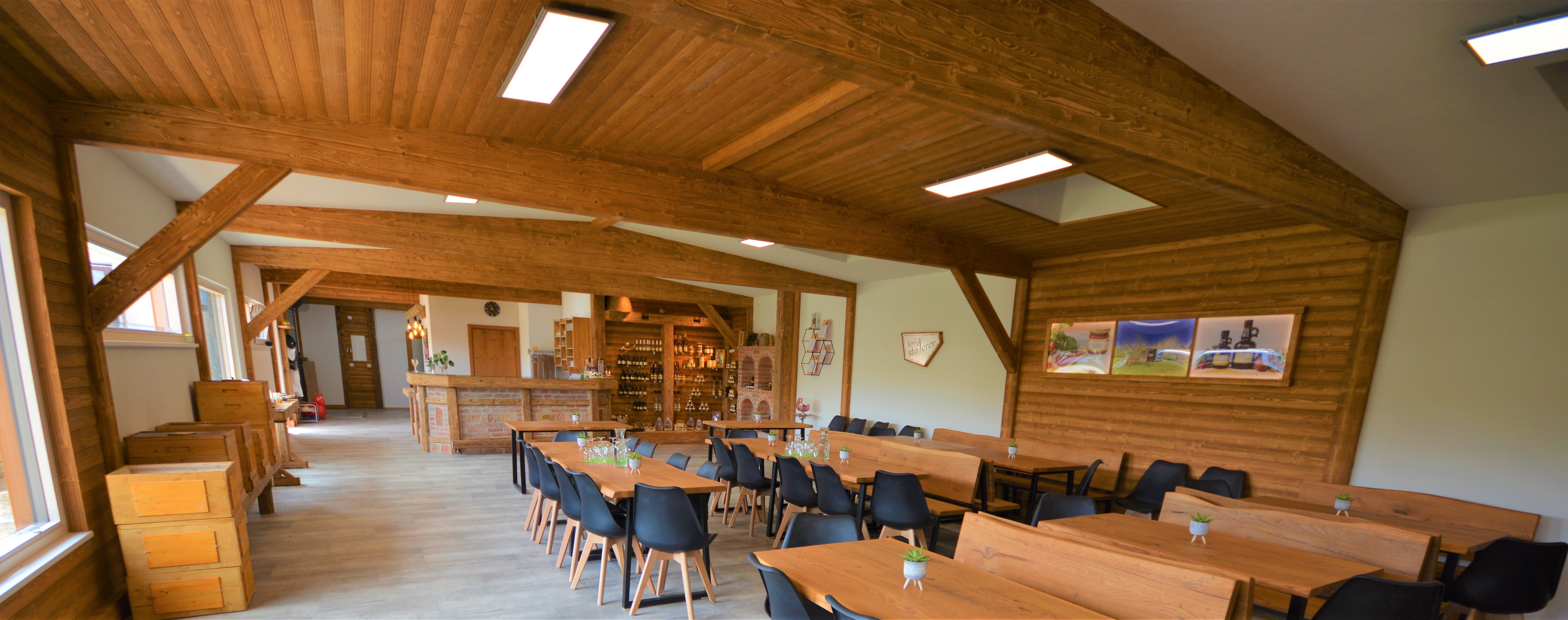 Innenansicht eines rustikalen Raumes mit Holzmöbeln und Dekorationen.