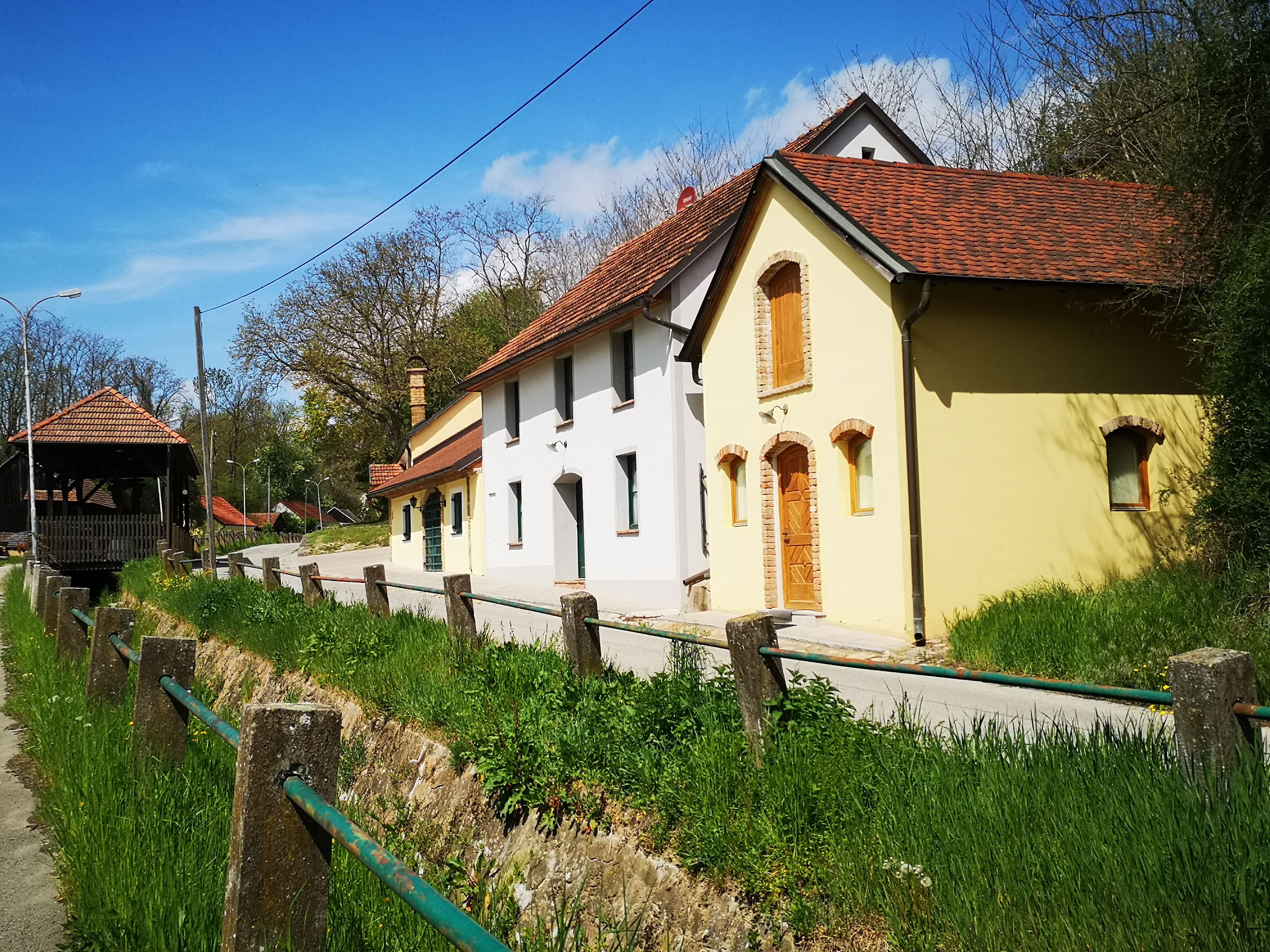 Traditionelle Weinkeller in einer Kellergasse, umgeben von Grünflächen