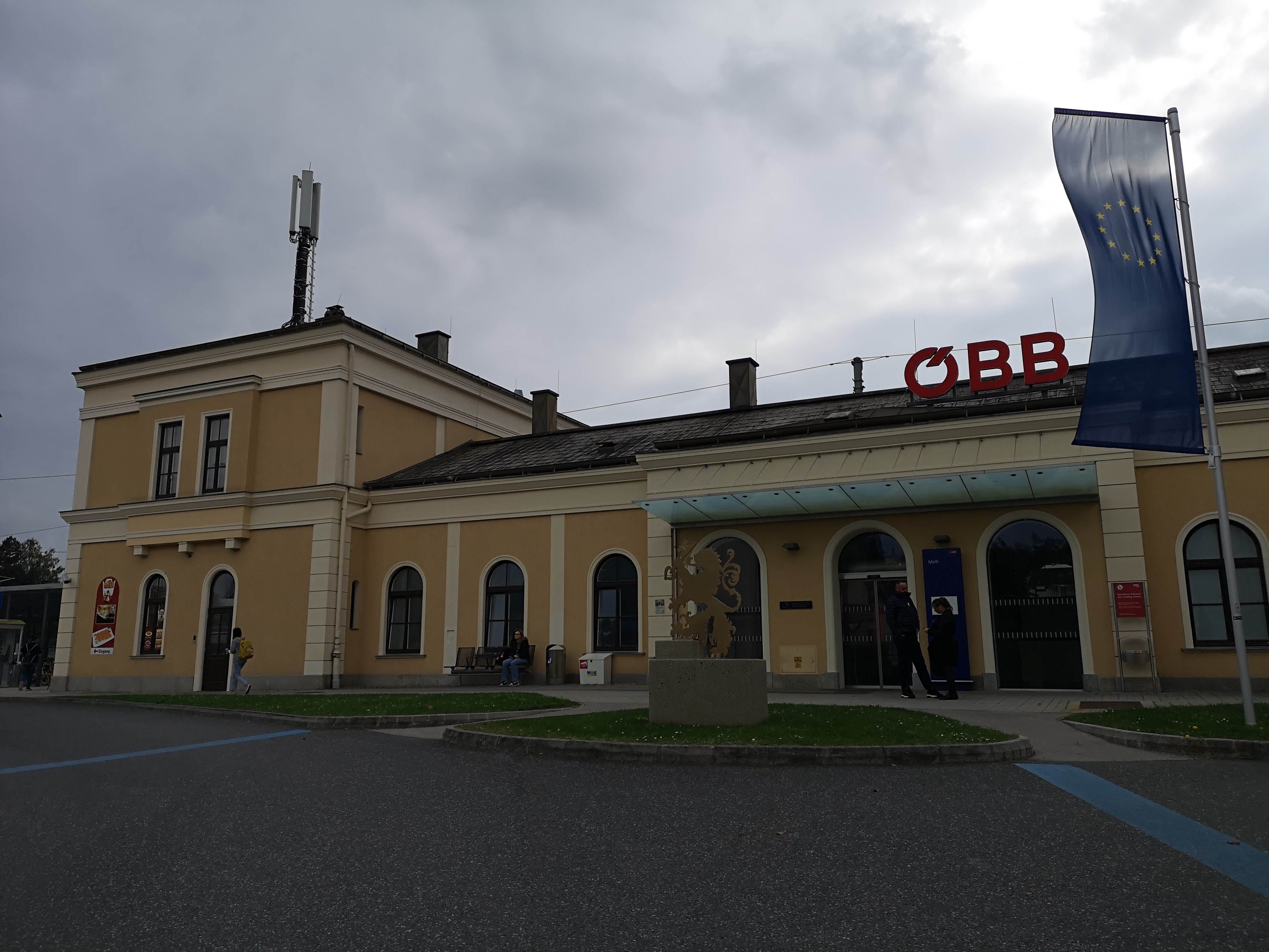 Bahnhof in Melk mit ÖBB-Logo und EU-Flagge.