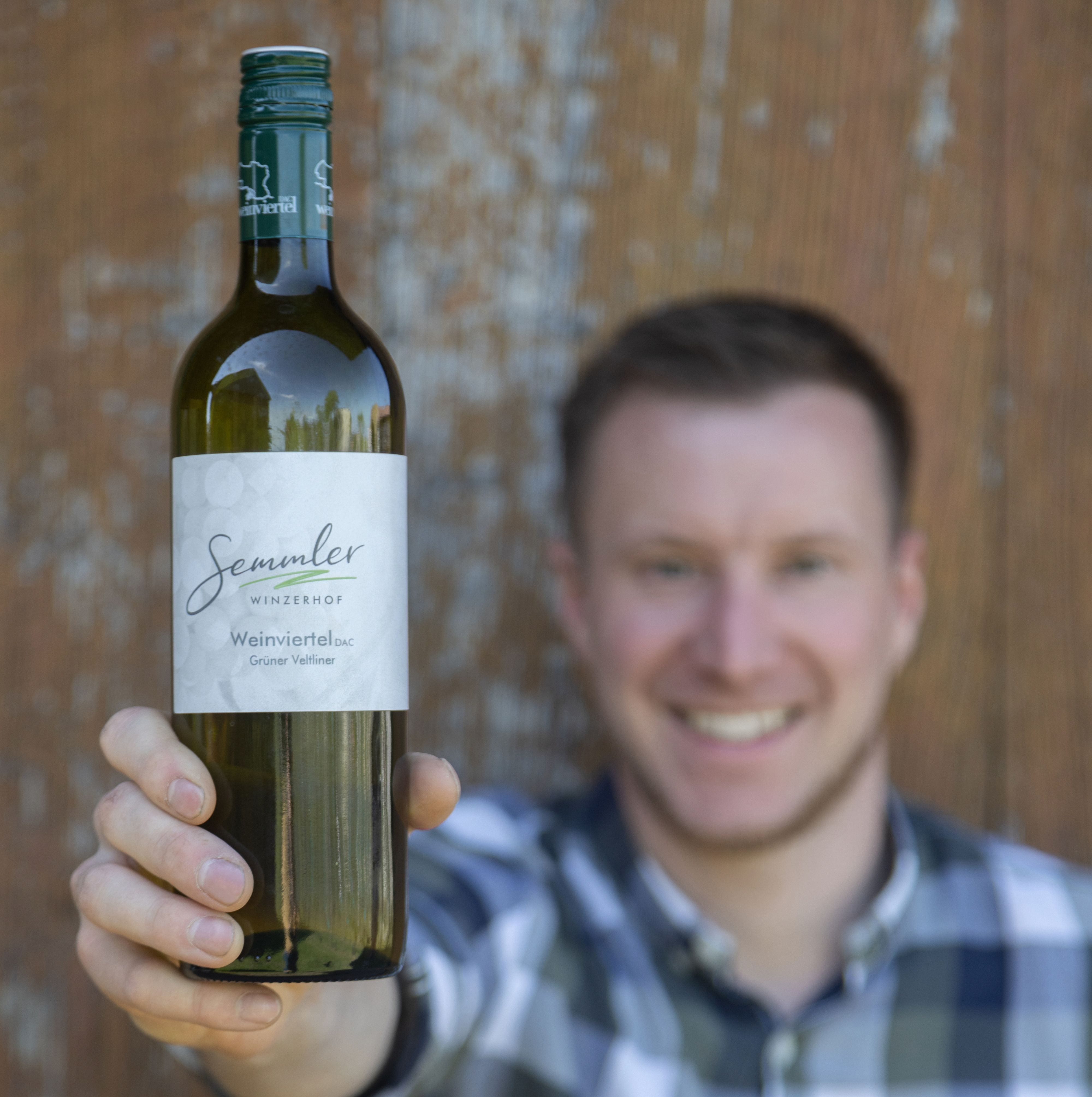 Ein Mann hält eine Flasche Wein vom Winzerhof Semmler in die Kamera.