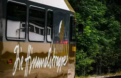 Die goldene Bahn schmiegt sich sanft in die umgebende Natur, während die Bäume im Hintergrund ein Gefühl von Ruhe und Abgeschiedenheit vermitteln. Hier, wo die Himmelstreppe die Landschaft durchquert, wird jeder Moment zu einem unvergesslichen Erlebnis in der malerischen Umgebung des Mostviertels.