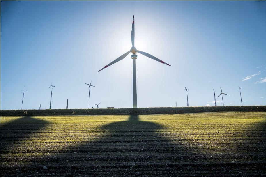 Windkraftanalge Lichtenegg und Kleinwindkraftanlagen auf einem Feld bei Sonnenuntergang.