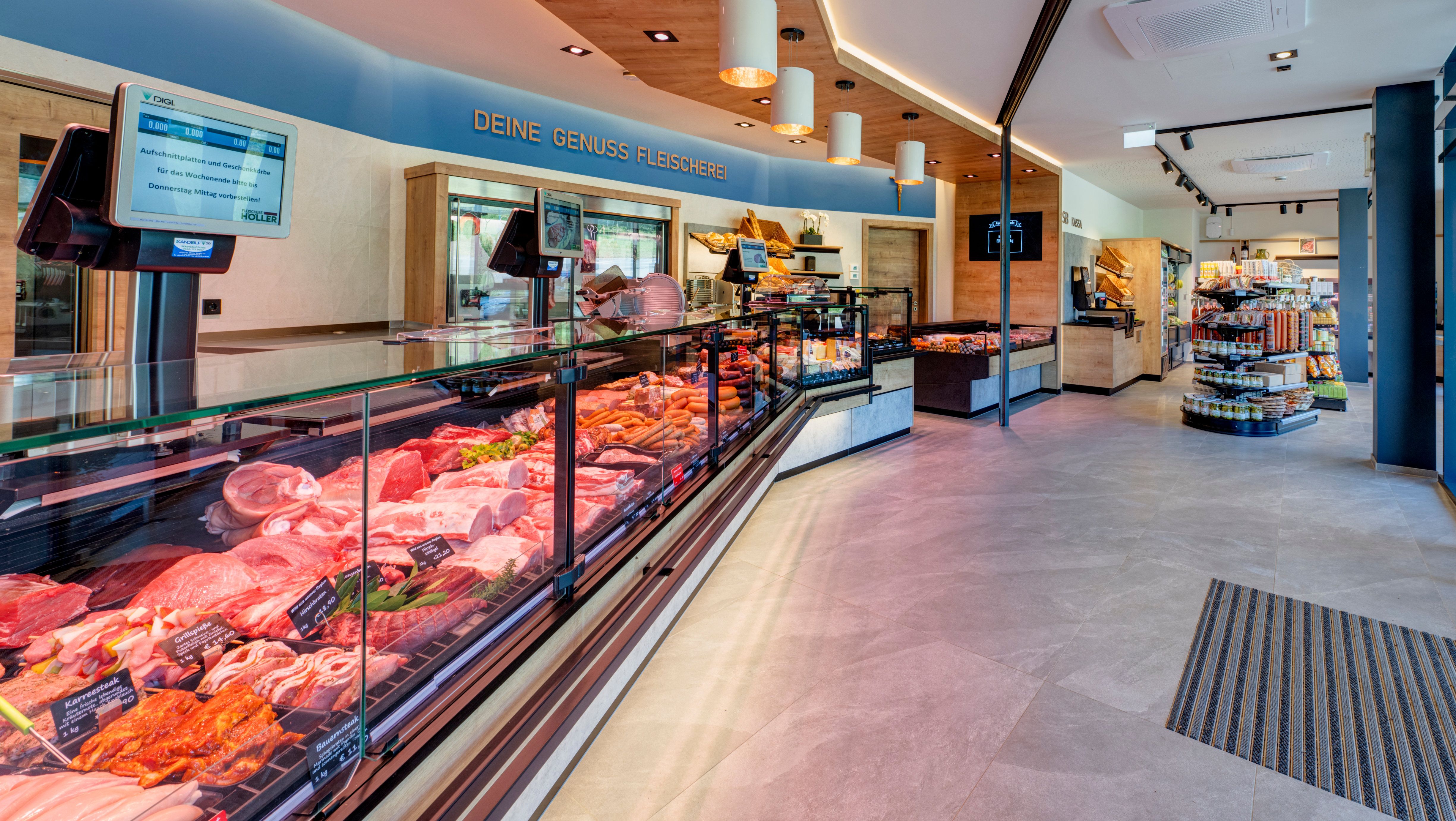 Verkaufsraum einer Fleischerei mit Vitrinen mit Fleisch und Wurstprodukten und Regalen.