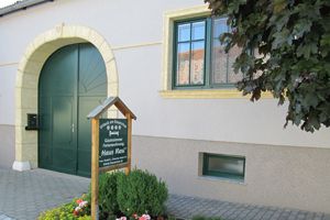 Eingang eines Gästehauses mit grünem Tor und Schild "Haus Resi".