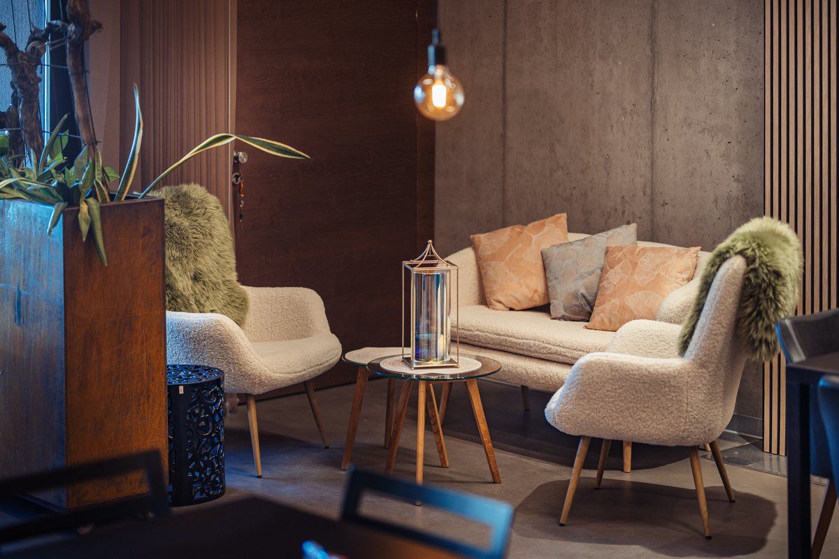 Gemütliche Sitzecke mit Sofa, Sesseln und Kissen.