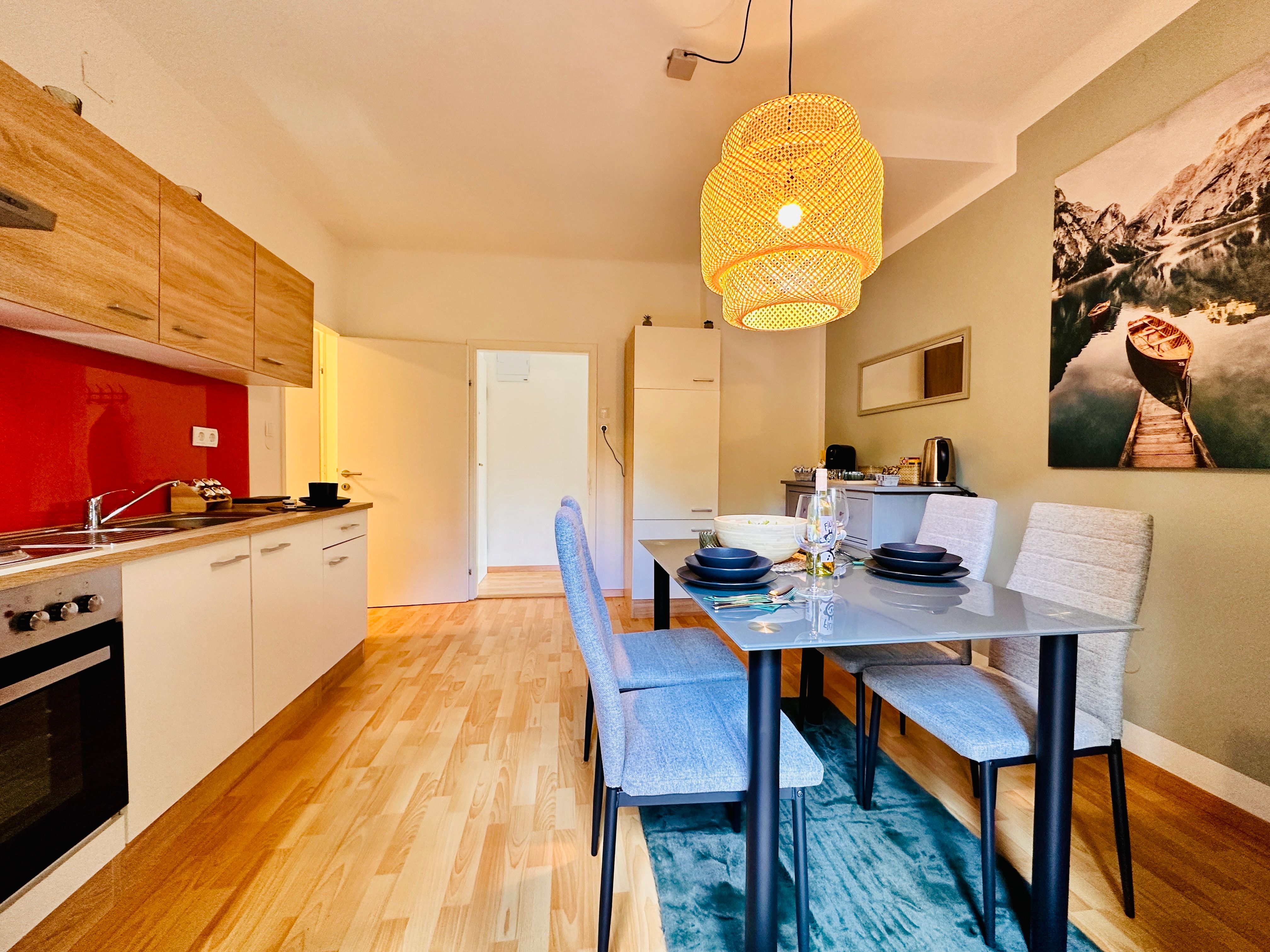 Moderne Küche mit Esstisch und Hängelampe.